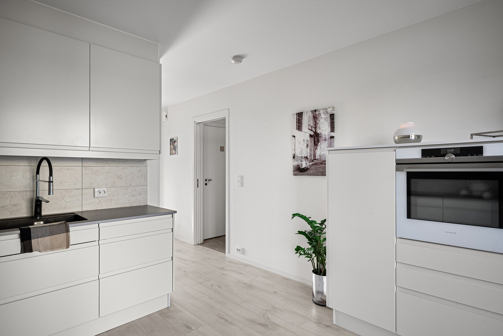 Et velutstyrt og delikat kjøkken m/rene linjer og mye skapplass. Lekker, hvit Siemens komfyr i praktisk arbeidshøyde. Galleribilde