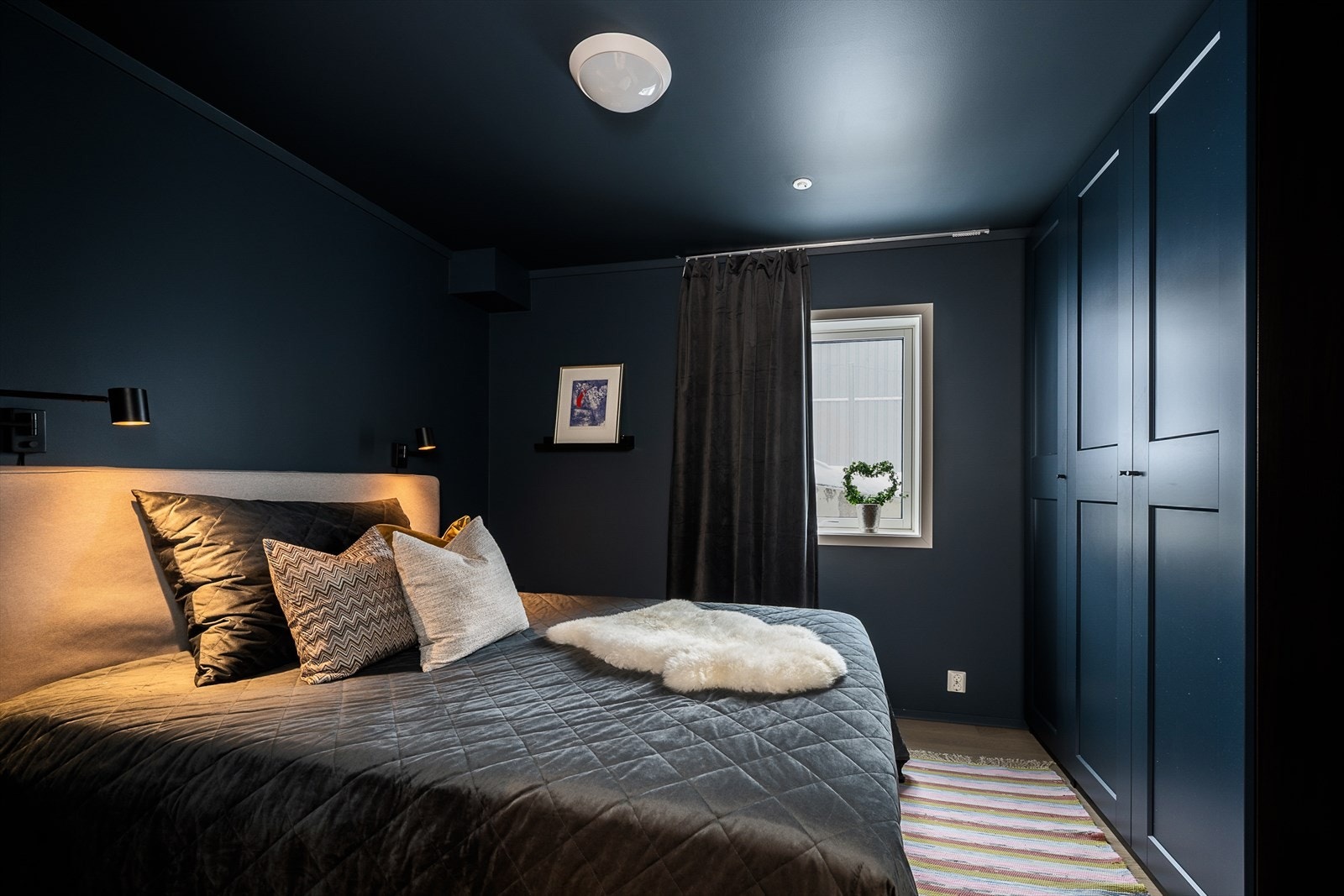 Soverommet er holdt i en mørk fargepalett, med plass til dobbeltseng og garderobeskap. Galleribilde
