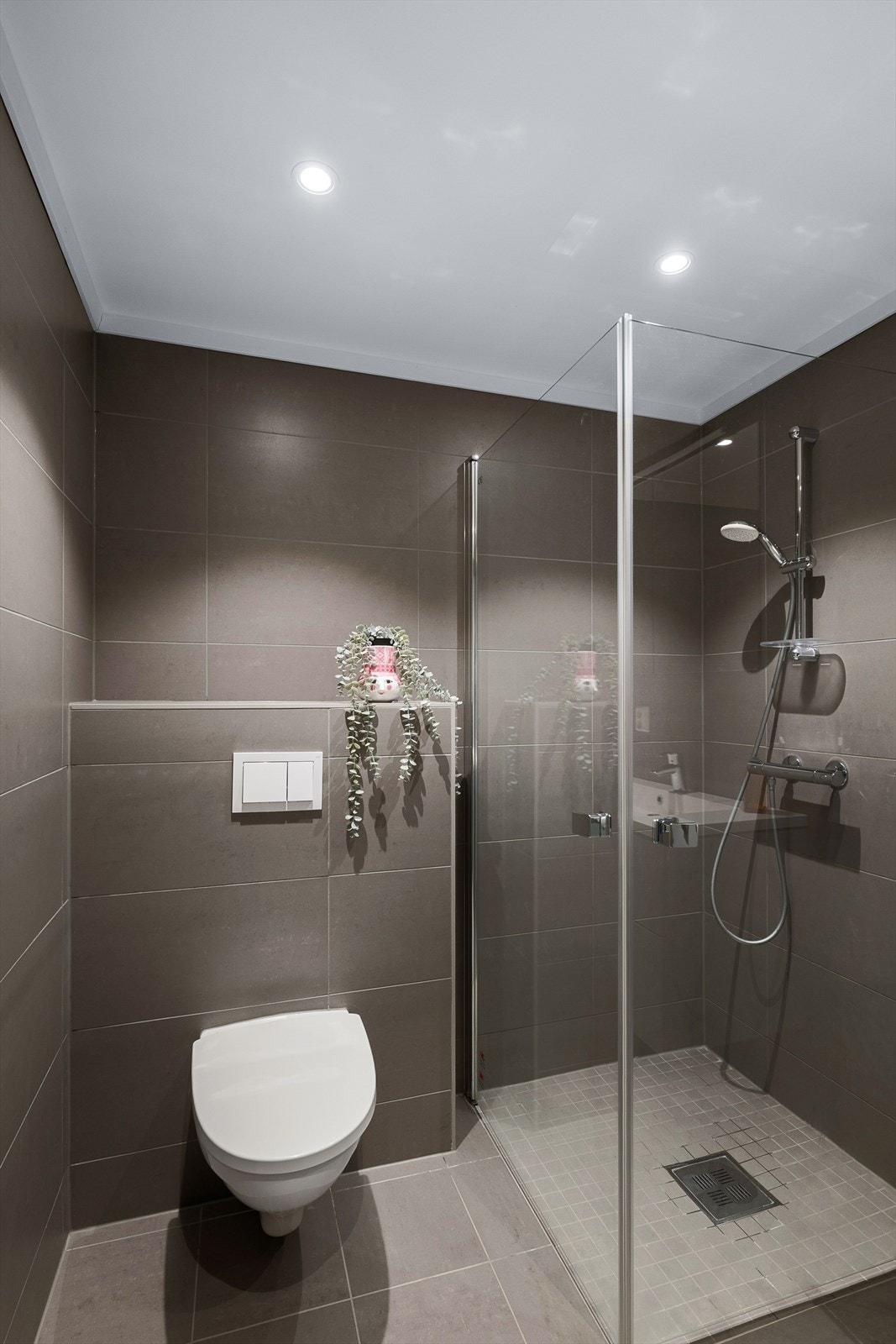 Her finnes vegghengt toalett og en romslig dusjsone med nedsenket gulv og dører i herdet glass. Galleribilde