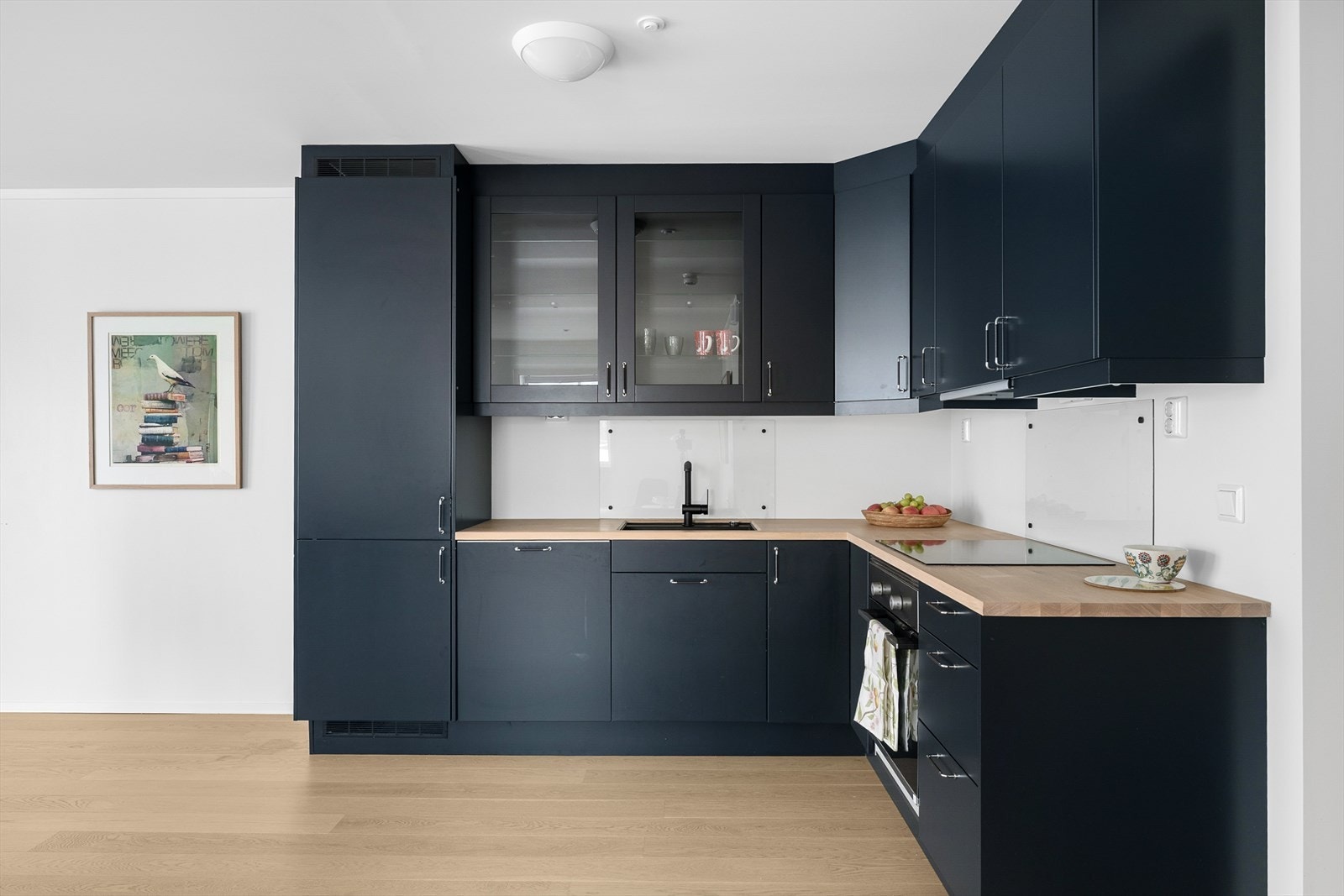 Det er oppsatt glassplate på veggen over kokesonen og vasken. Galleribilde