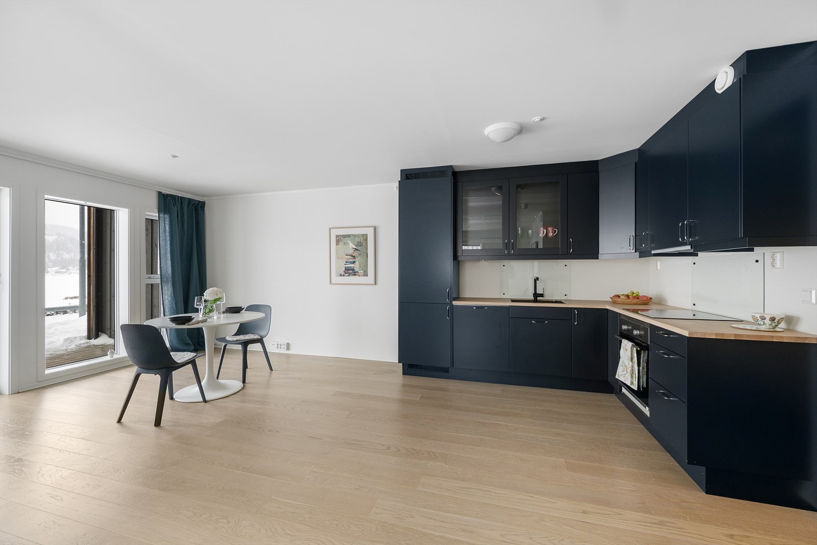 Kjøkkenet er moderne med mørke, glatte fronter og god skapplass. Galleribilde