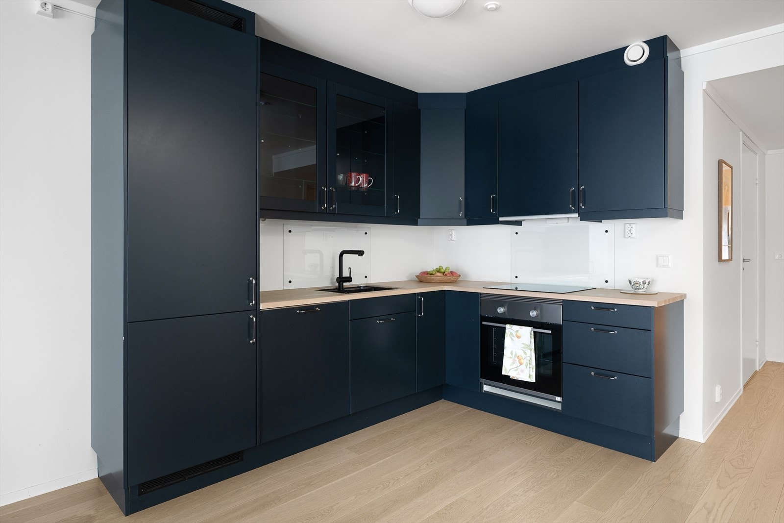 Innredningen har en solid benkeplate i heltre og integrerte hvitevarer som komfyr og oppvaskmaskin. Galleribilde