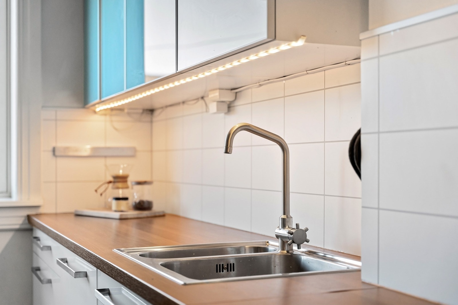 Kjøkkenet har glatte fronter, benkeplate med laminert overflate og laminerte plater over benken Galleribilde