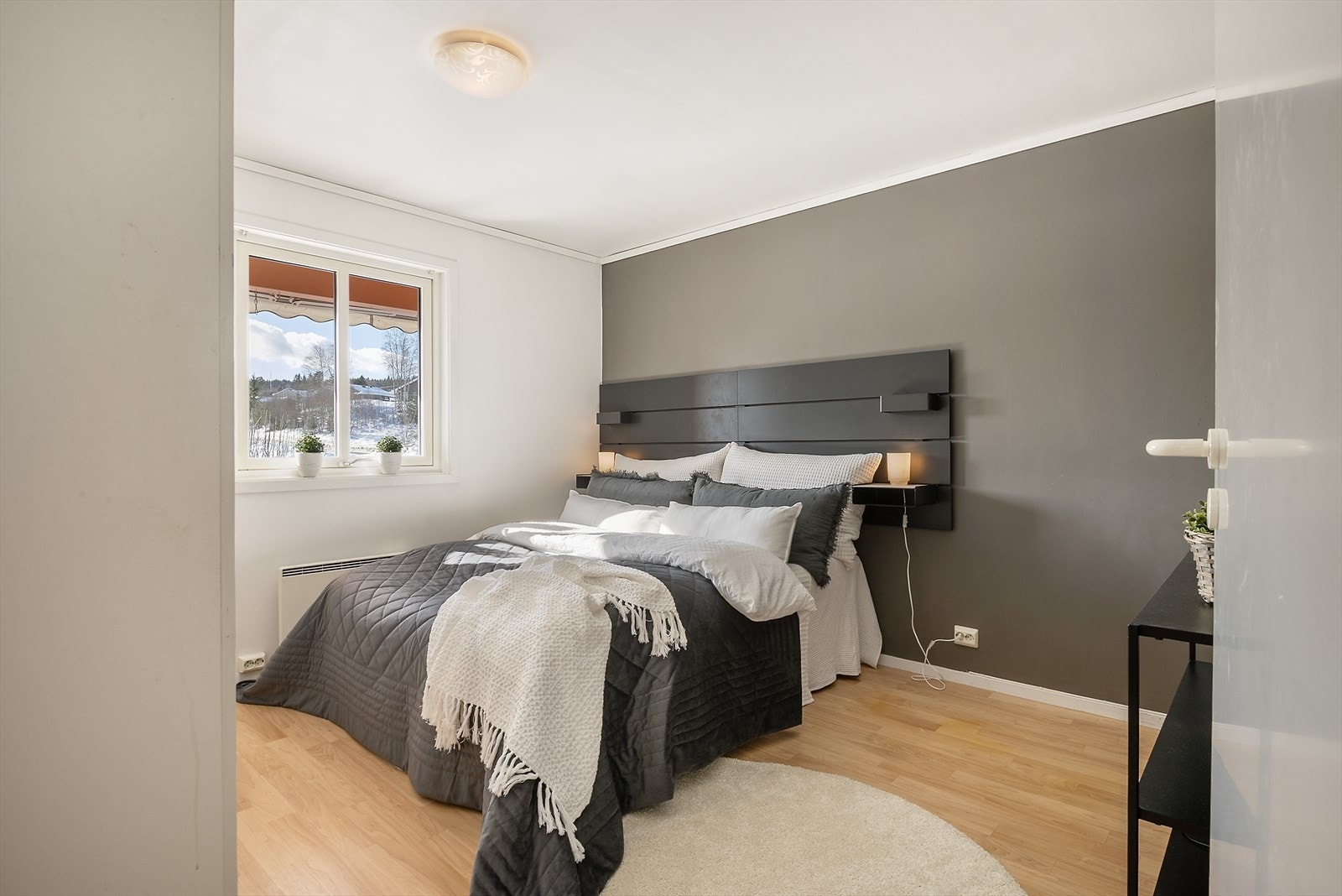 Lyst soverom med parkettgulv og slettmalte vegger gir et moderne preg. Galleribilde