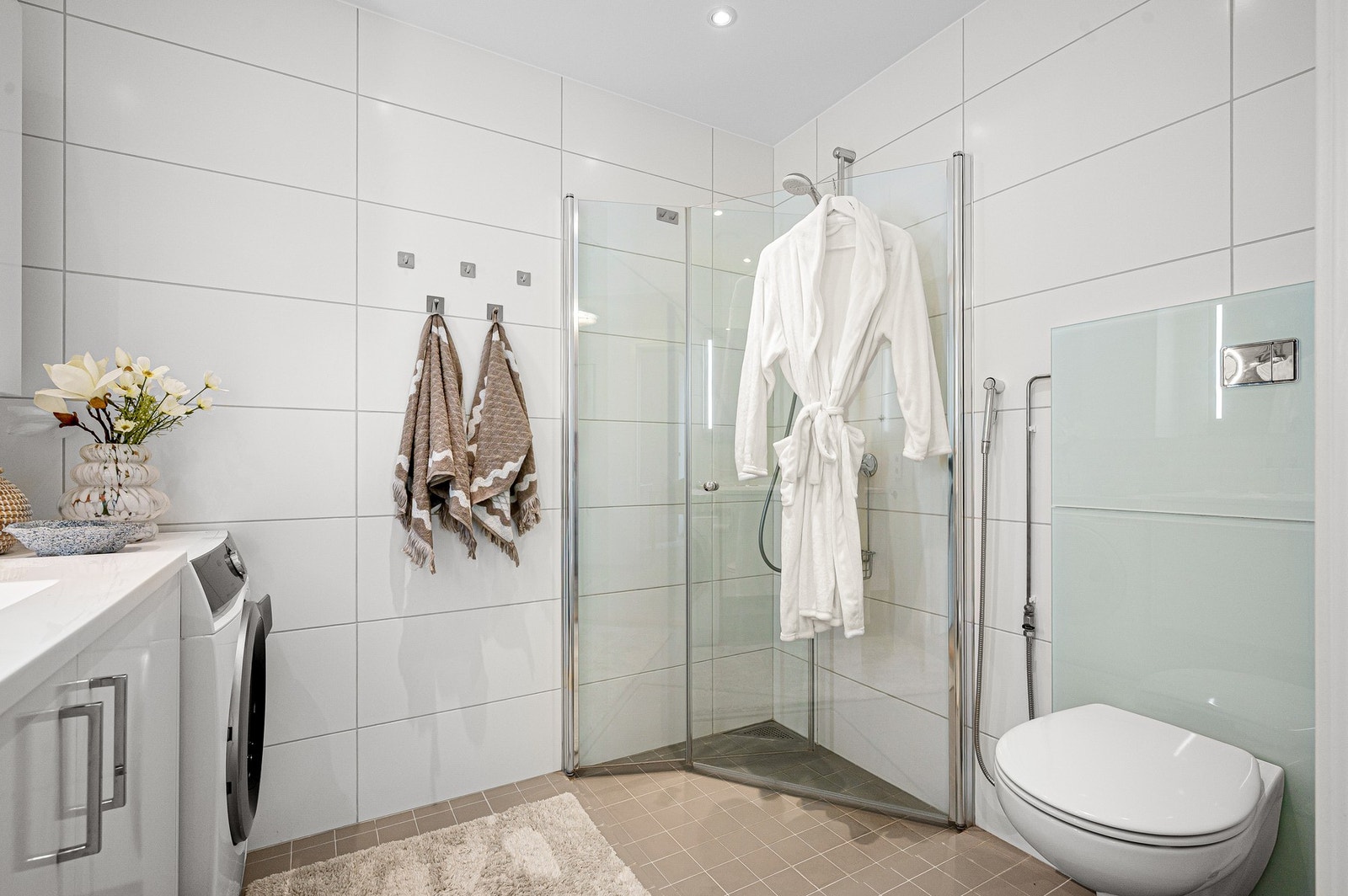 Baderommet har vegghengt WC, dusjsone, servant med underskap og speil. Galleribilde