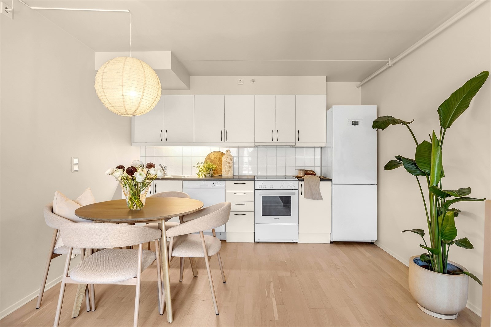 Pent, tidløst kjøkken fra byggeår. Kjøkkeninnredning med hvite glatte fronter, benkeplate i laminat. Galleribilde