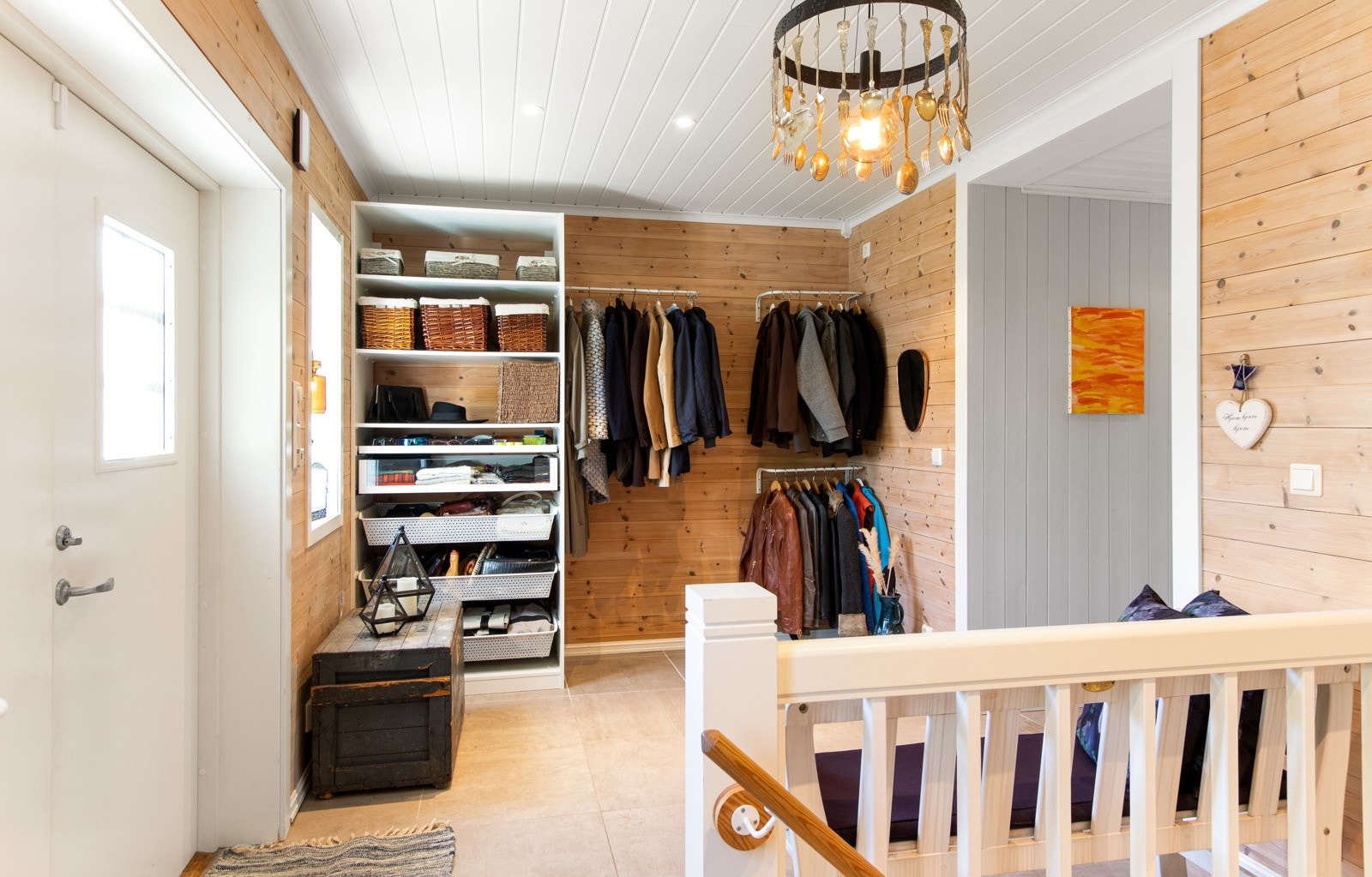 Her ønsker boligen velkommen inn i et romslig entrérom med store gulvfliser, liggende trepanel på vegger, downlights og behagelig gulvvarme. Galleribilde