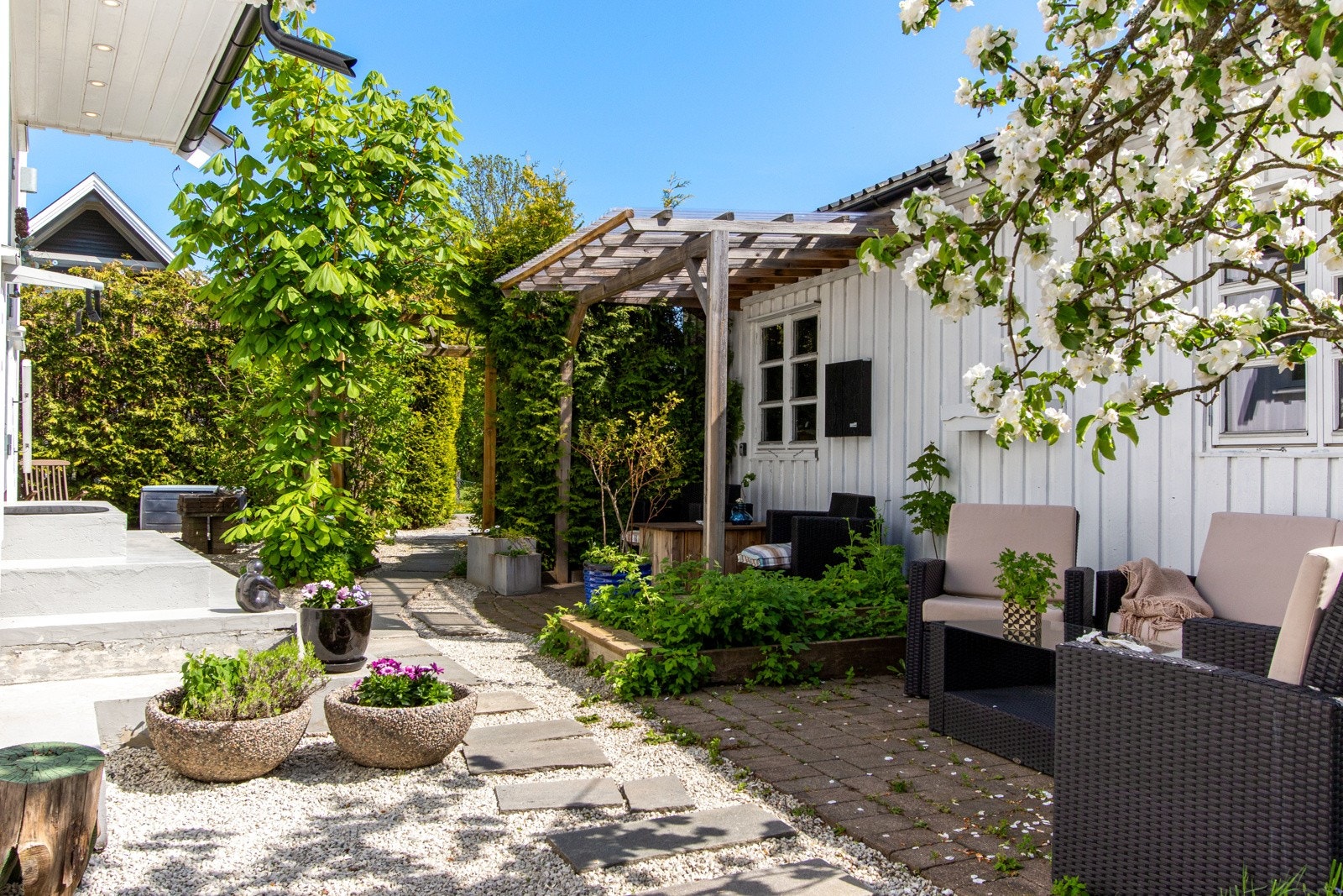 Eneboligen ligger omkranset av en idyllisk og frodig hage, samt gårdsplass med belegningsstein. Galleribilde