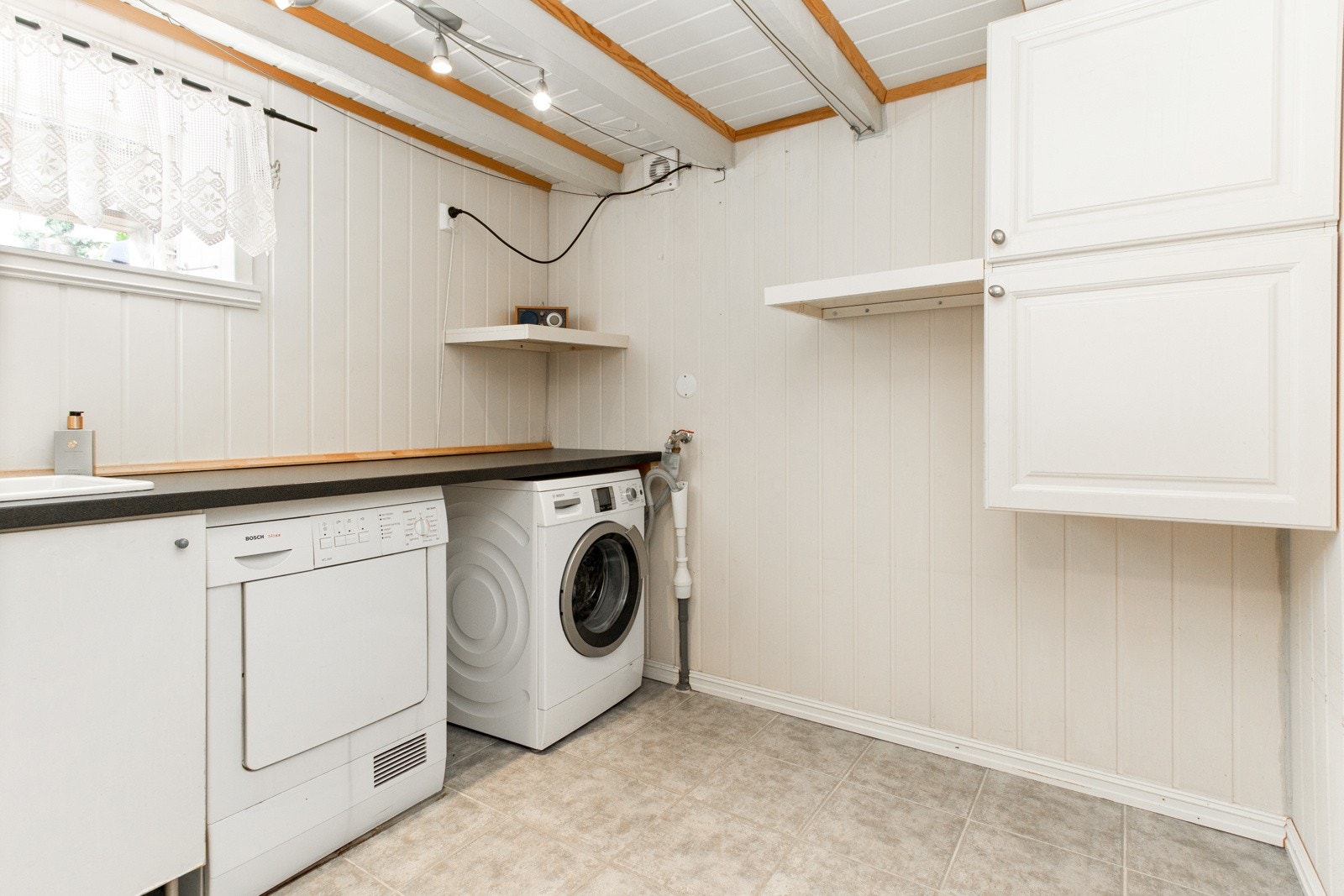 I kjelleretasjen har boligen et lyst vaskerom praktisk utstyrt med flislagt dusjhjørne. Galleribilde
