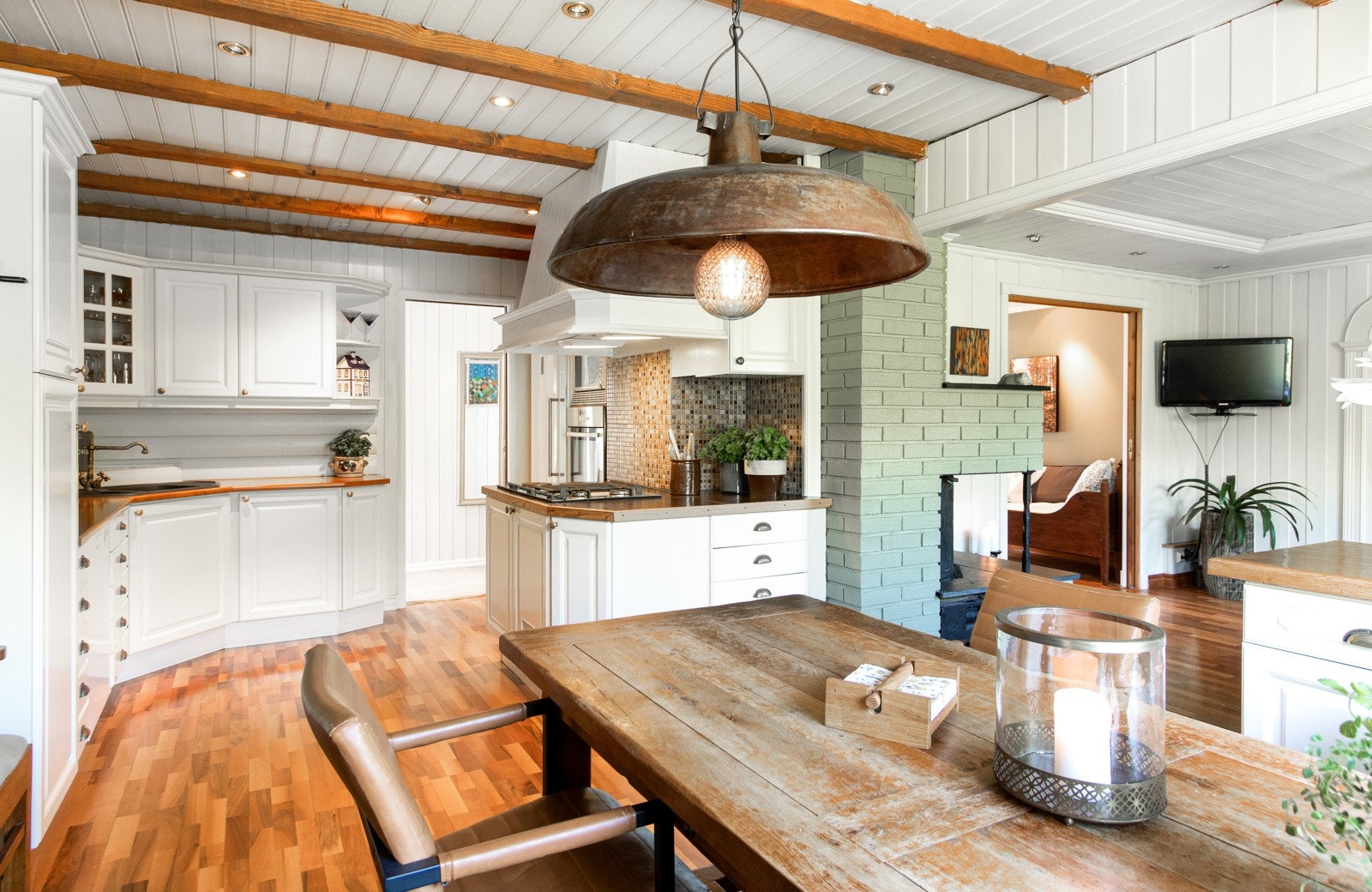 Innredningen har lyse, profilerte fronter, vitrineskap og laminat benkeplate med benkebeslag i kompositt. Galleribilde