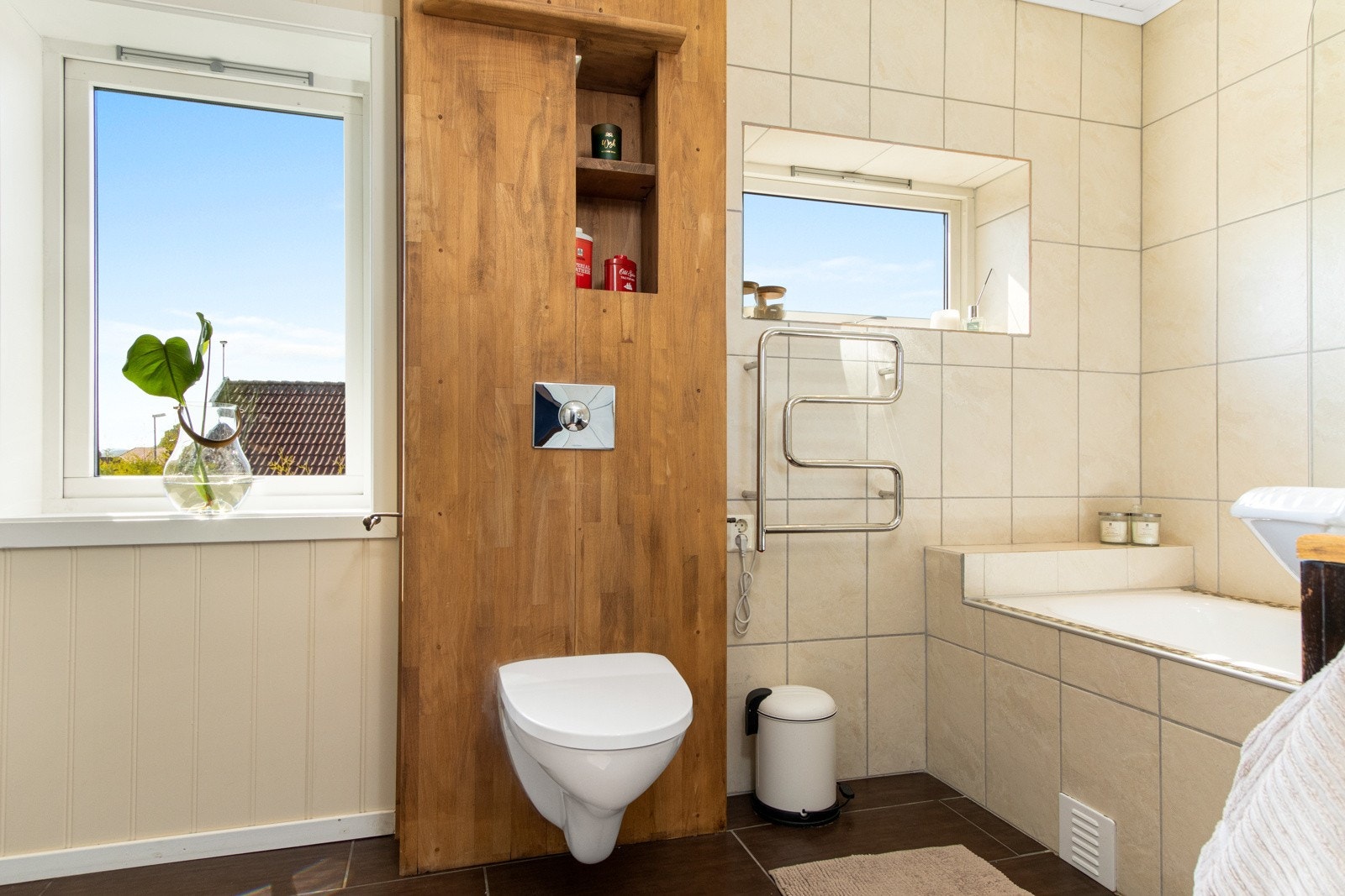 Badet får naturlig lys fra flere vinduer og det er opplegg for vaskemaskin og innfliset badekar med dusjvegg. Badet har også elektrisk håndkletørker. Galleribilde