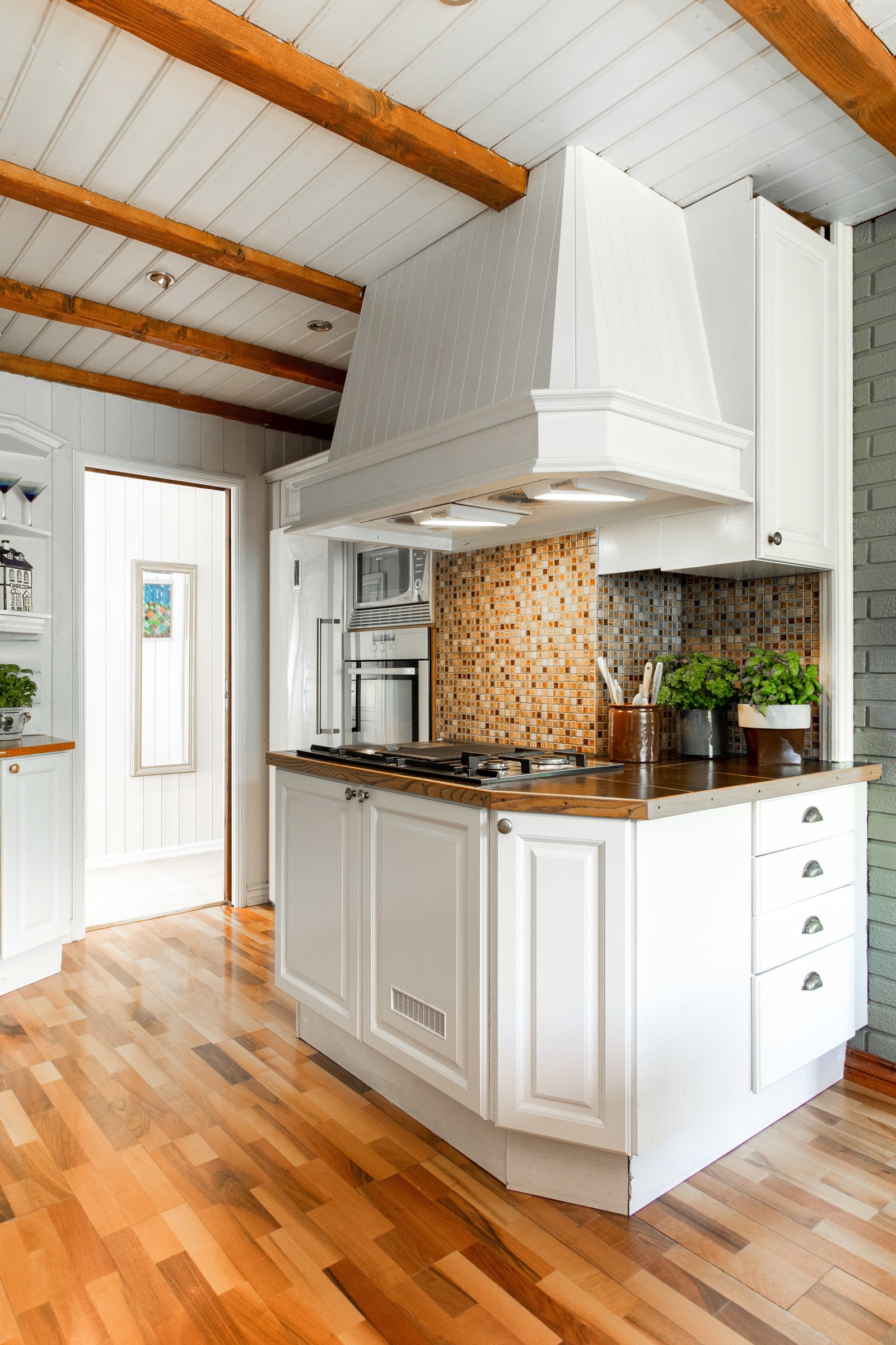 Kjøkkenet har gassbluss med innbygget gassbeholder, mosaikkfliser i bakkant av kokesonen og en Futurum ventilatorhette i overkant. Galleribilde