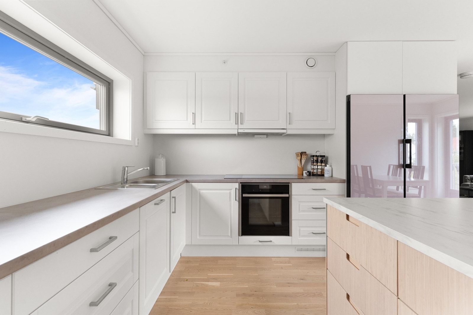 Leiligheten har en stilren kjøkkeninnredning med integrerte hvitevarer. Kjøleskap/fryseskap, oppvaskmaskin og platetopp på kjøkken (selger etablerer ny benkeplate før overtakelse i lik stil som kjøkkenøy). Galleribilde