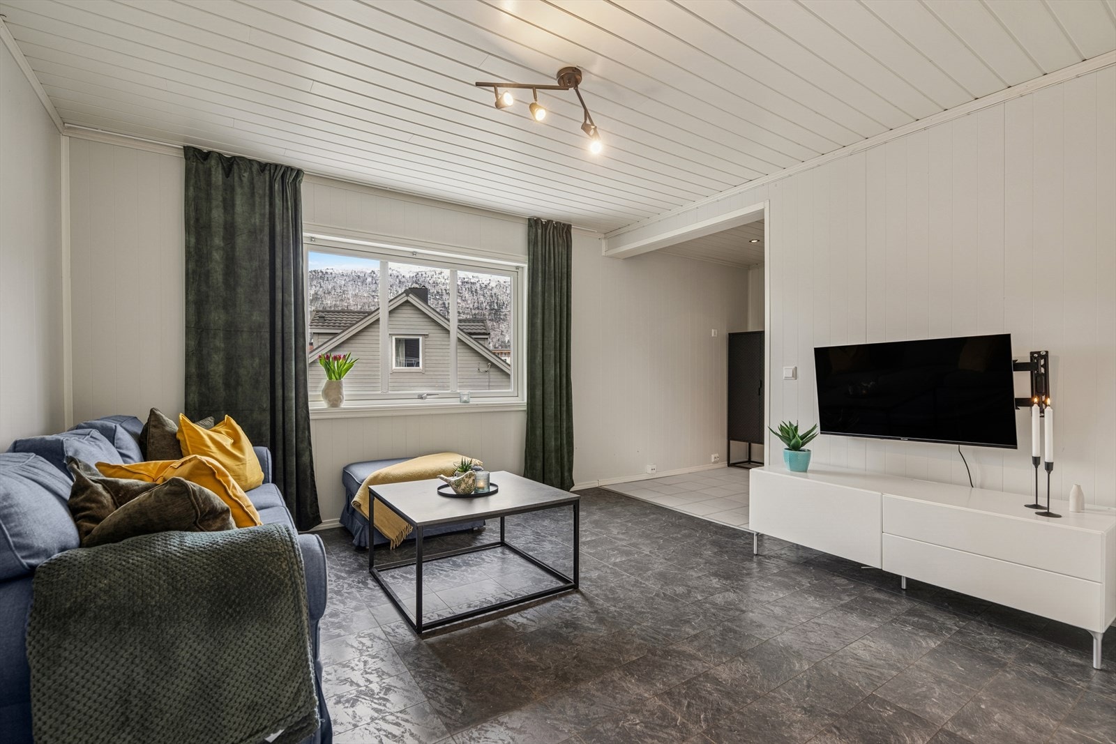 Lys og åpen stue med vinduer i tre himmelretninger som gir et luftig preg. Galleribilde