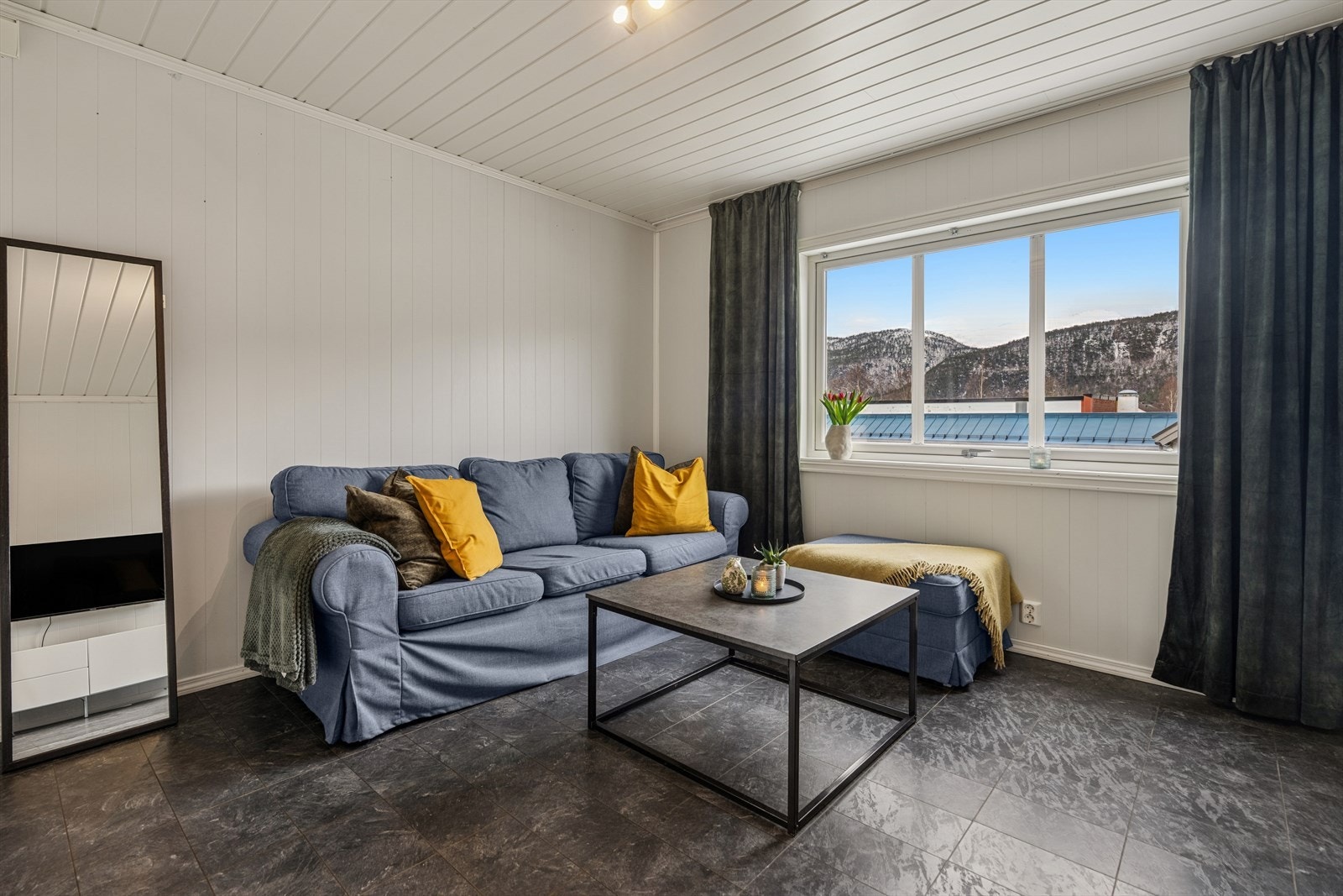 Romslig stue/kjøkkenløsning med naturlig møbleringssone og moderne overflater. Galleribilde