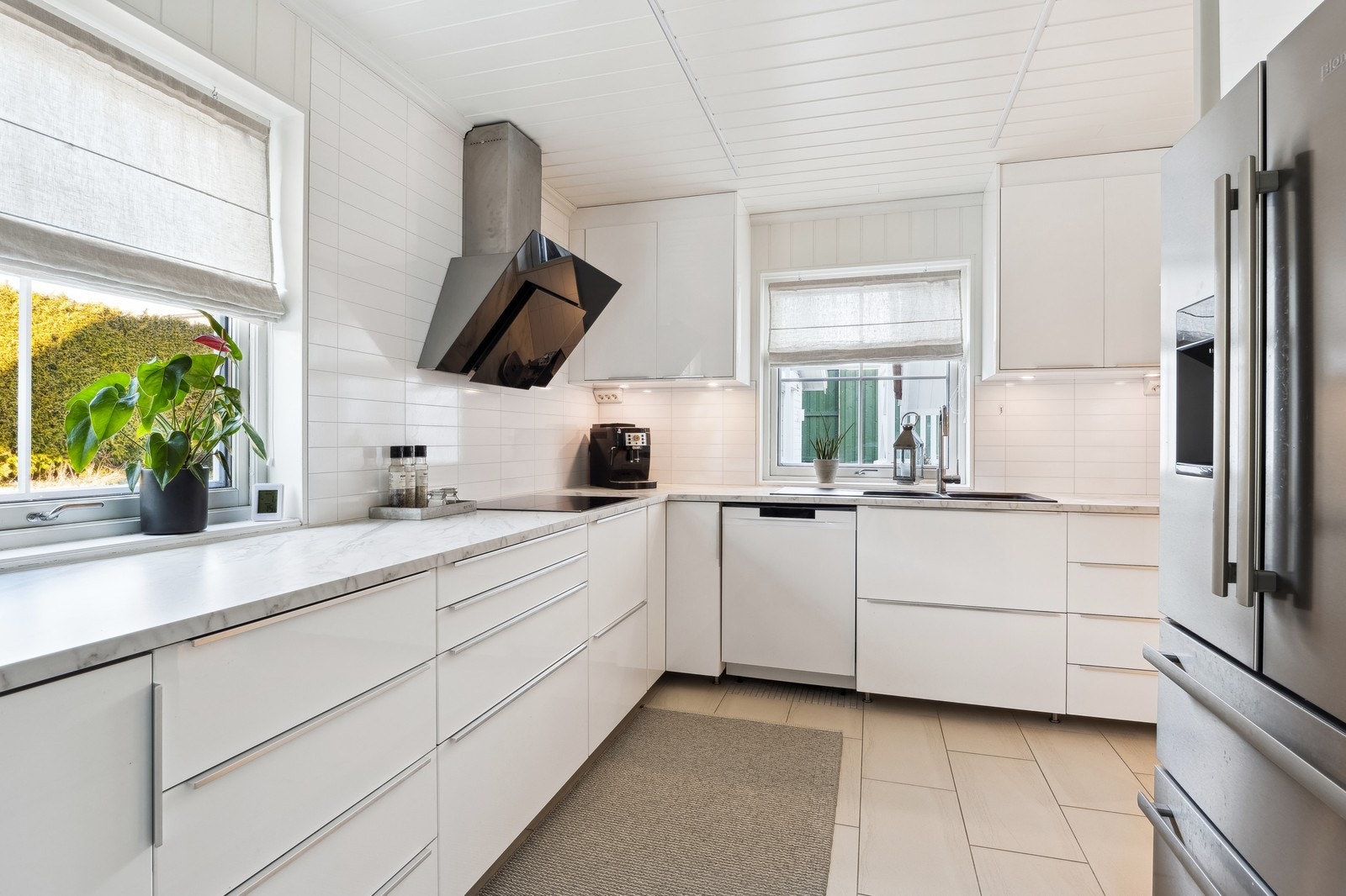 Lekkert kjøkken med god skap- og benkeplass. Innredningen har hvite fronter og laminert benkeplate Galleribilde