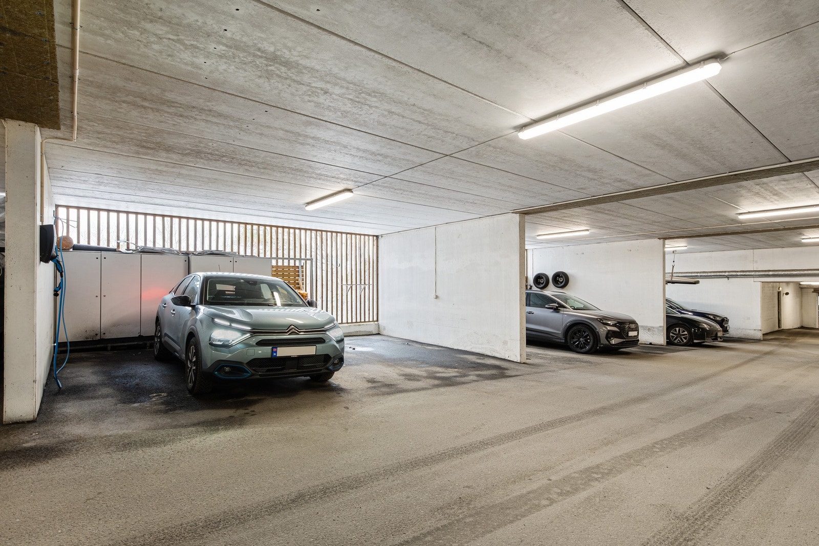 Leiligheten har to garasje-plasser. Elbillader på den ene plassen. Skap for lagring er praktisk Galleribilde