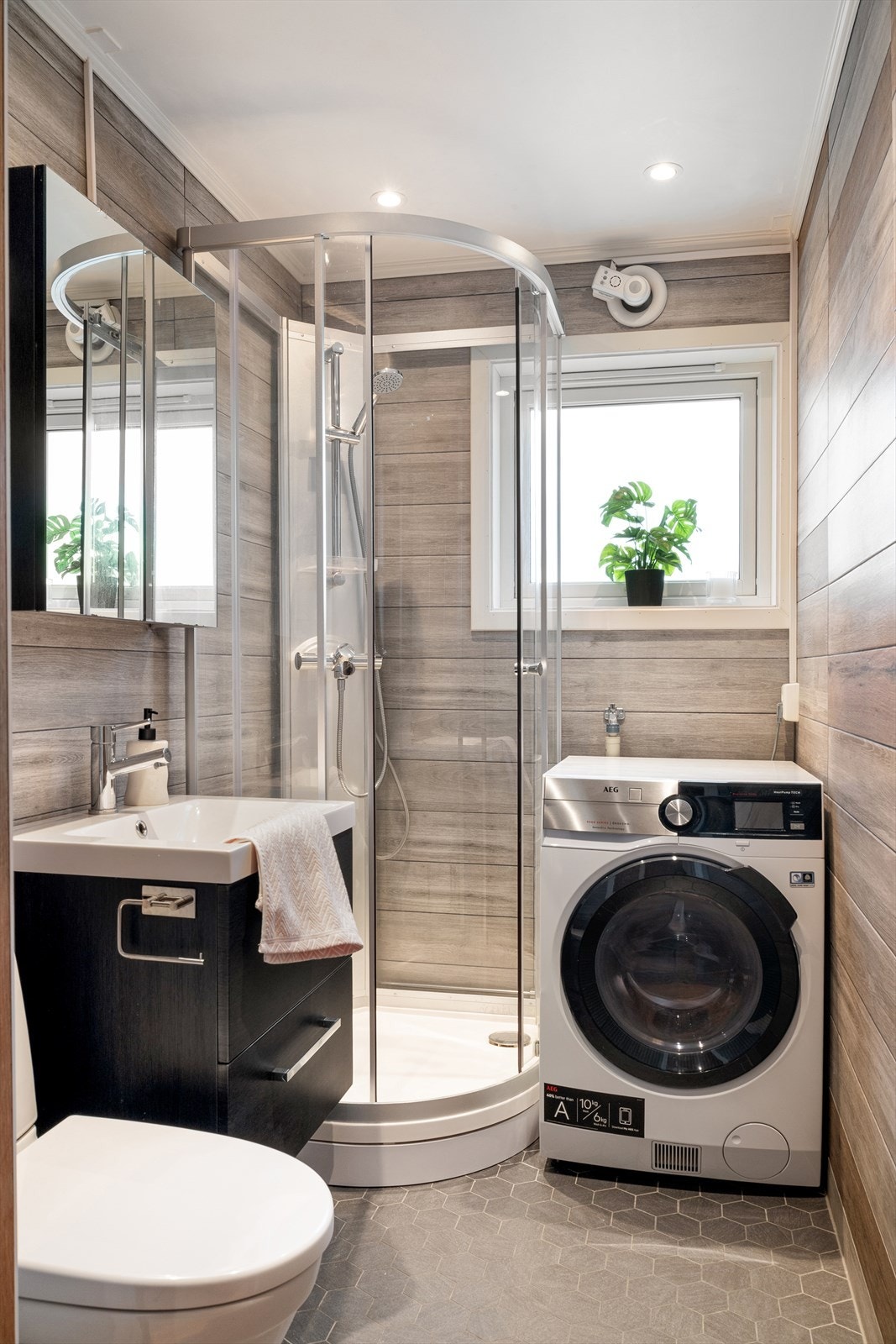 Badet er innredet med servantskap, speil, toalett og dusjkabinett. Det er også opplegg for vaskemaskin. Galleribilde