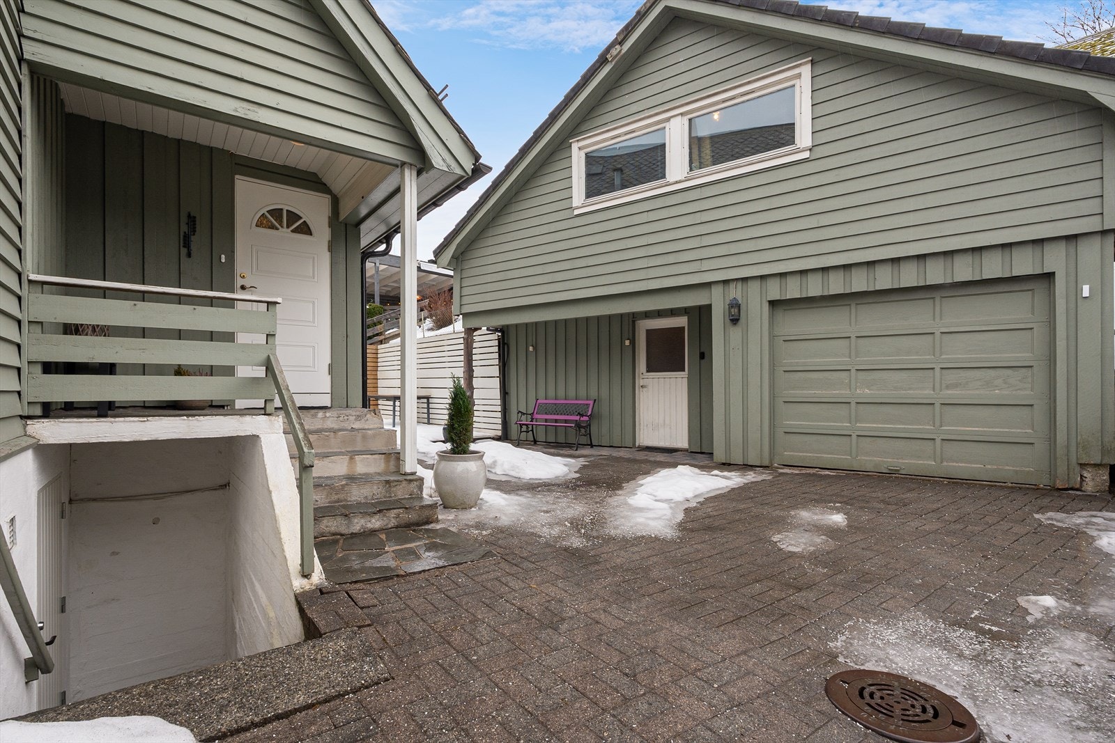 Tun med eldre uthus med garasje, som i dag er brukt til lagringsplass. Tunet er belagt med belegningsstein. Galleribilde