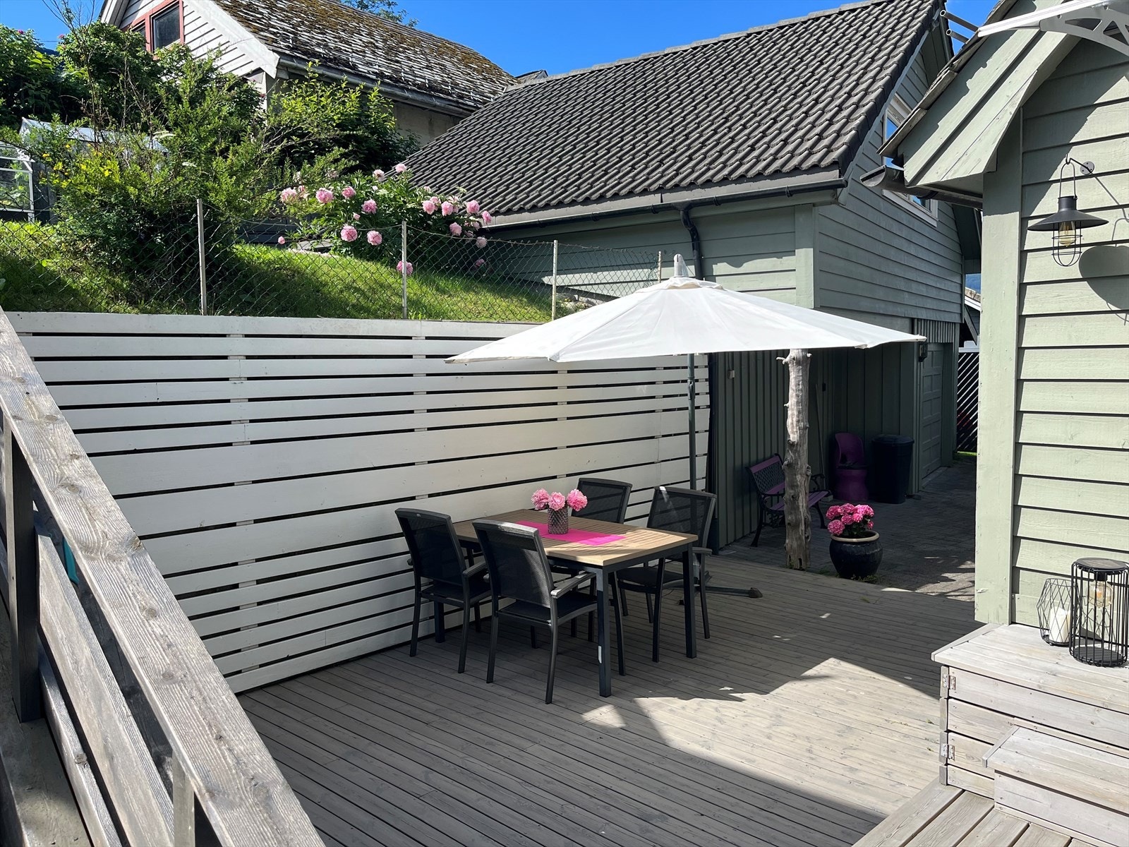 Inngangsparti med terrasse, hage og prydbusker. Galleribilde