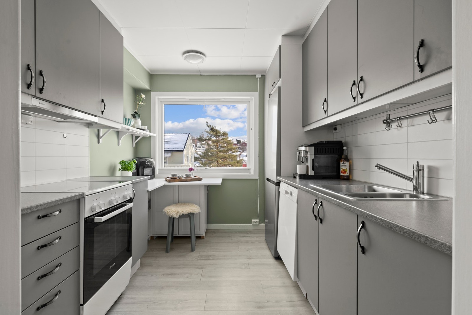 HTH kjøkkeninnredning med glatte fronter. Benkeplaten er av laminat og det er vannstoppsystem og komfyrvakt. Galleribilde