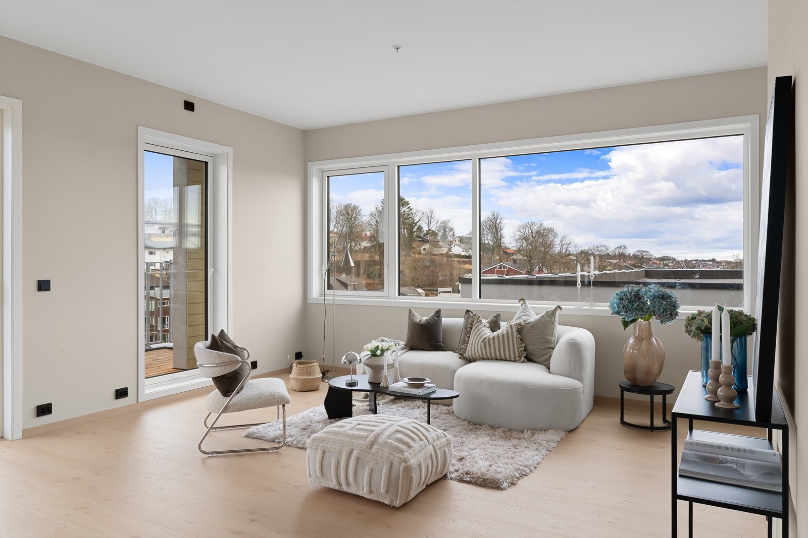 Leilighetens stue fremstår som lys og trivelig med store vindusflater som slipper inn mye naturlig lys som er med på å skape en god romfølelse og atmosfære. Galleribilde