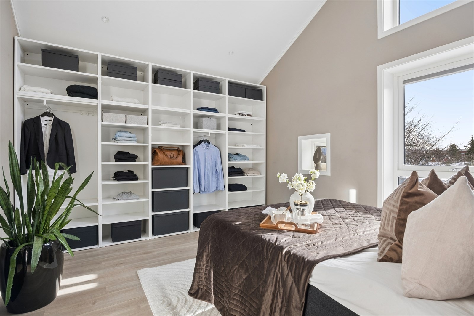 En hel vegg med åpen garderobeløsning gir rikelig med oppbevaringsplass. Galleribilde