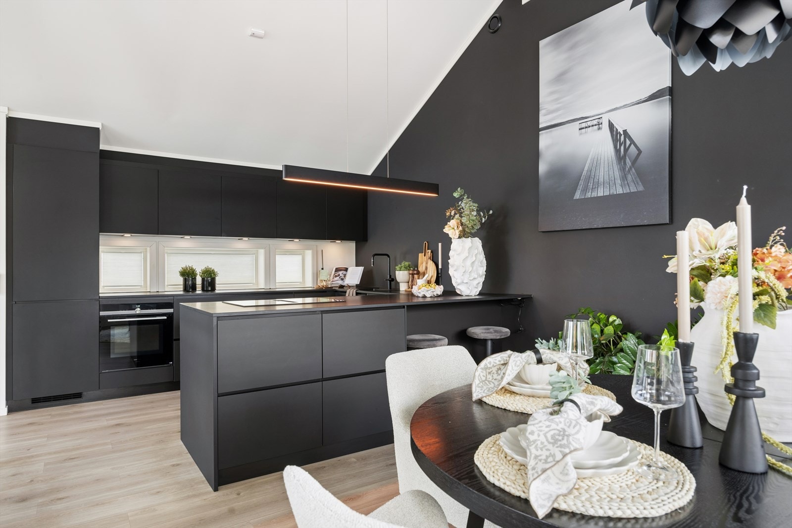 Kjøkkenet har slette fronter, laminert benkeplate og en praktisk kjøkkenøy med spiseplasser. Galleribilde