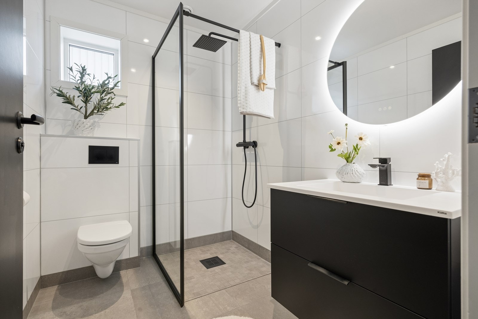 Badet i første etasje har våtromsplater på vegg, vegghengt toalett og dusj med glassvegg. Galleribilde