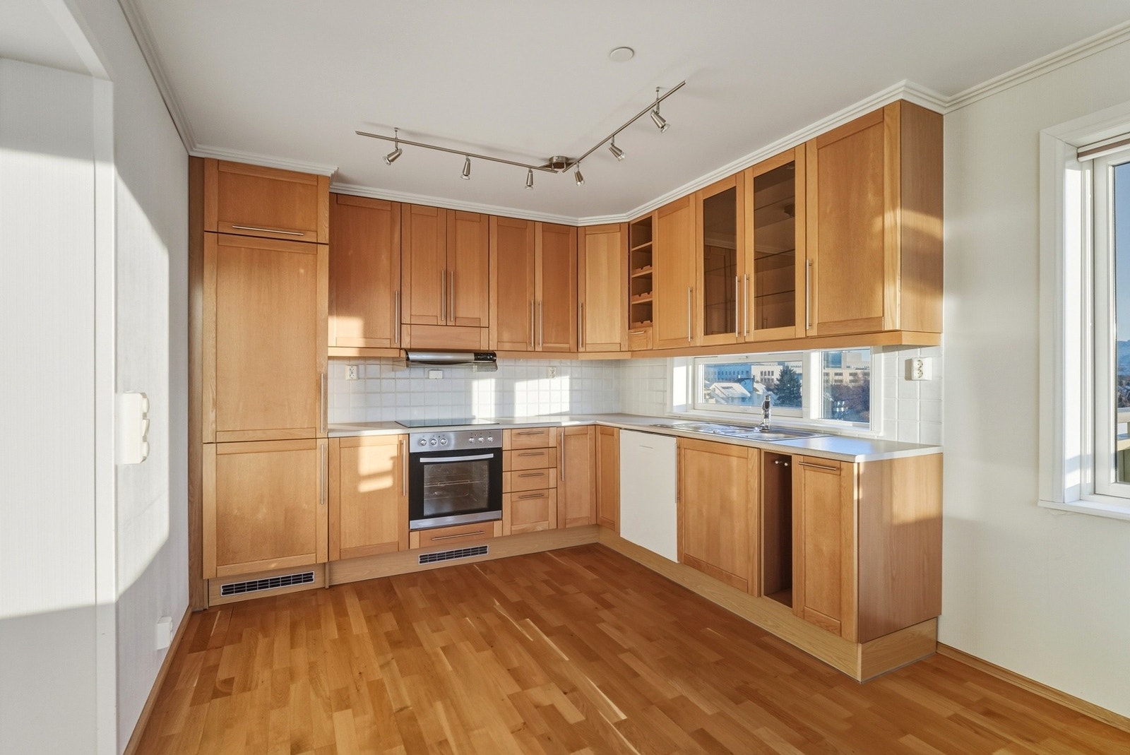 Det er fliser under overskap og benkeplate med nedfelt servant. Galleribilde