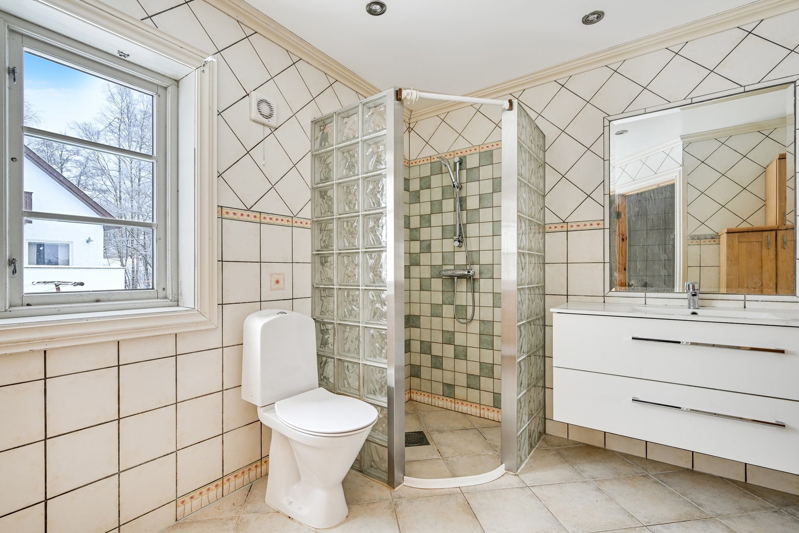 Badet i første etasje har fliser på gulv og vegger. Galleribilde