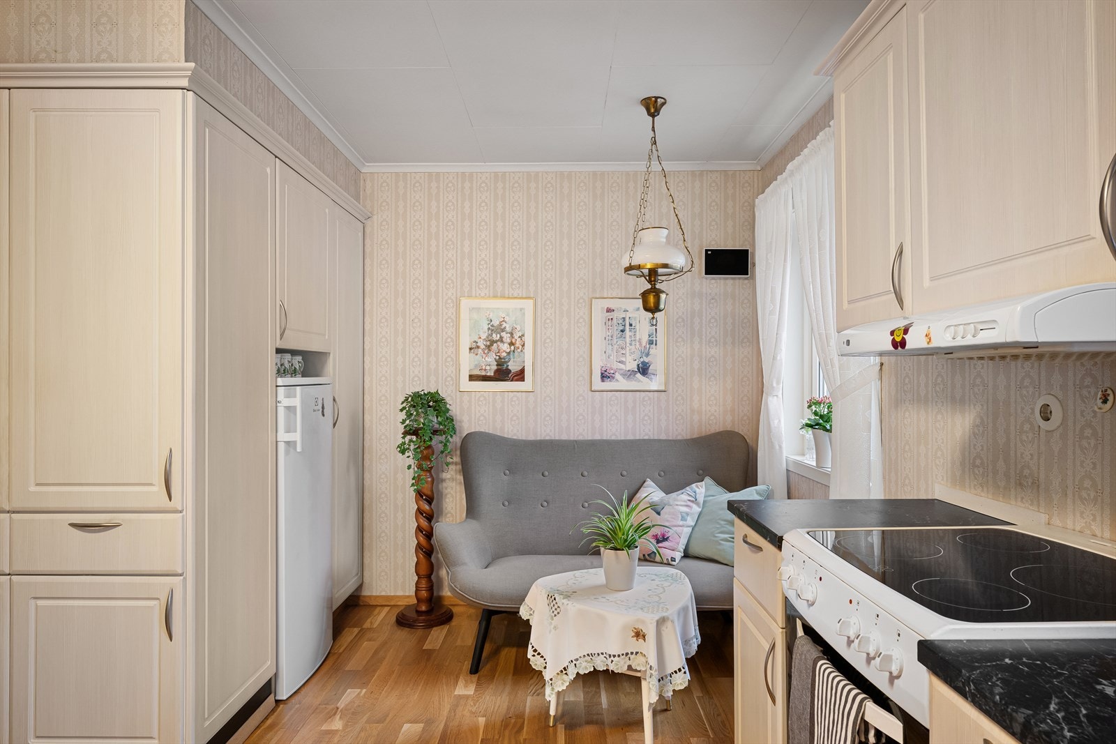 Et romslig kjøkken fornyet i ca. 2016 som innbyr til sosial samling med både lite spisebord og en lounge for avslapning. Rikelig med skapplass og arbeidsbenk. Fint utsyn til egen bakhage og mye naturlig lys. Galleribilde