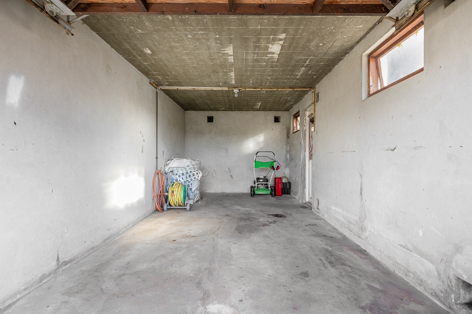 Garasjen har plass til lagring i bakkant av bilen. Murvegger. Galleribilde
