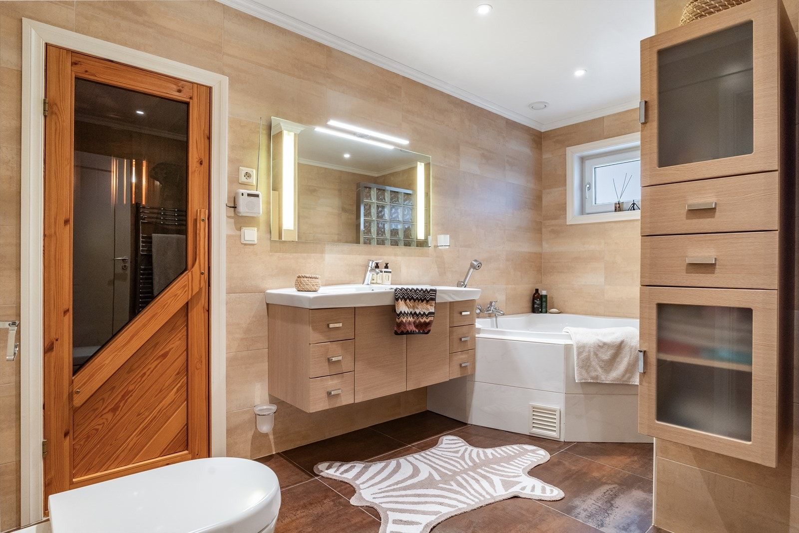 Badet i andre etasje er utstyrt med hjørnebadekar, dusj, badstue og baderomsinnredning fra Dansani med 120 cm porselen servant. Galleribilde