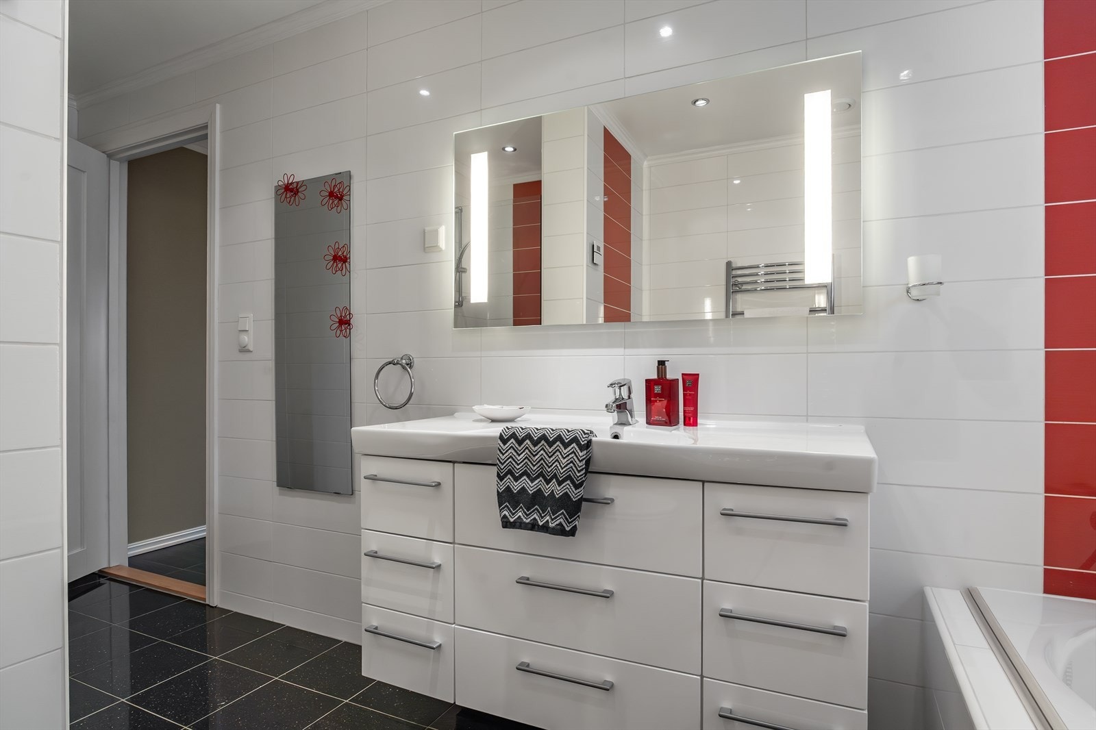 Helfliset bad i første etasje med badekar, dusj og baderomsinnredning med tilsvarende servant. Galleribilde