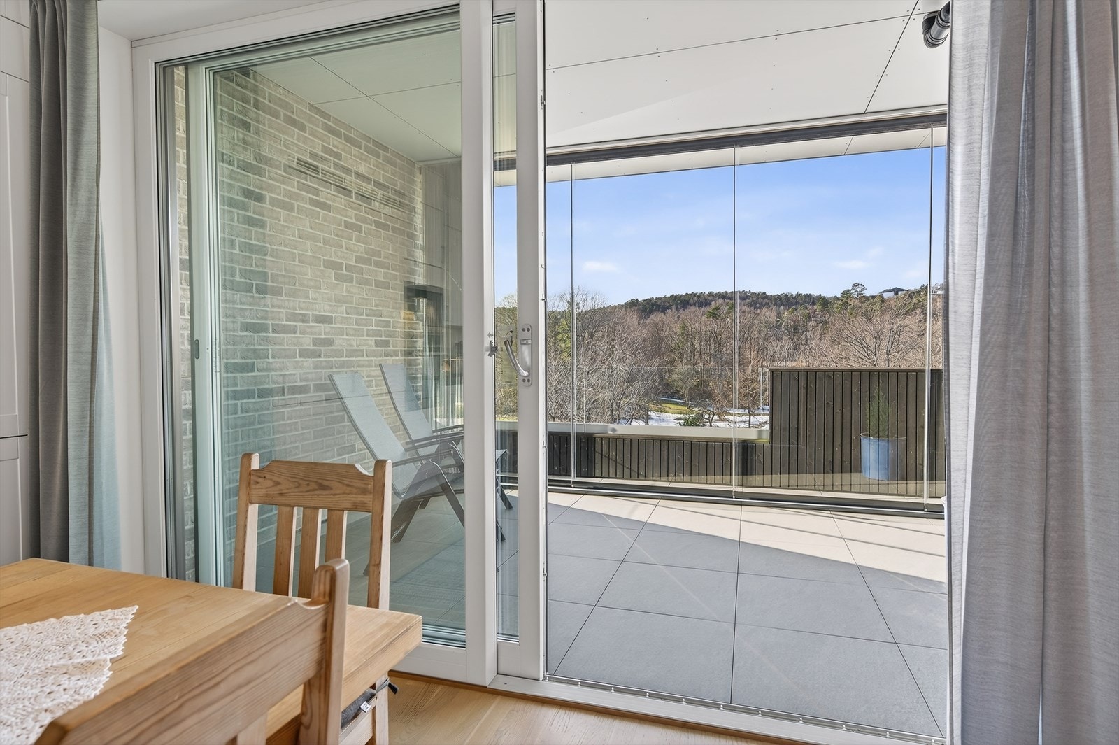 En av to skyvedører ut til innglasset balkong på hele 20 kvm. Meget praktisk å kunne nyte et godt måltid ute på balkongen med direkte utgang fra kjøkkendelen. Galleribilde