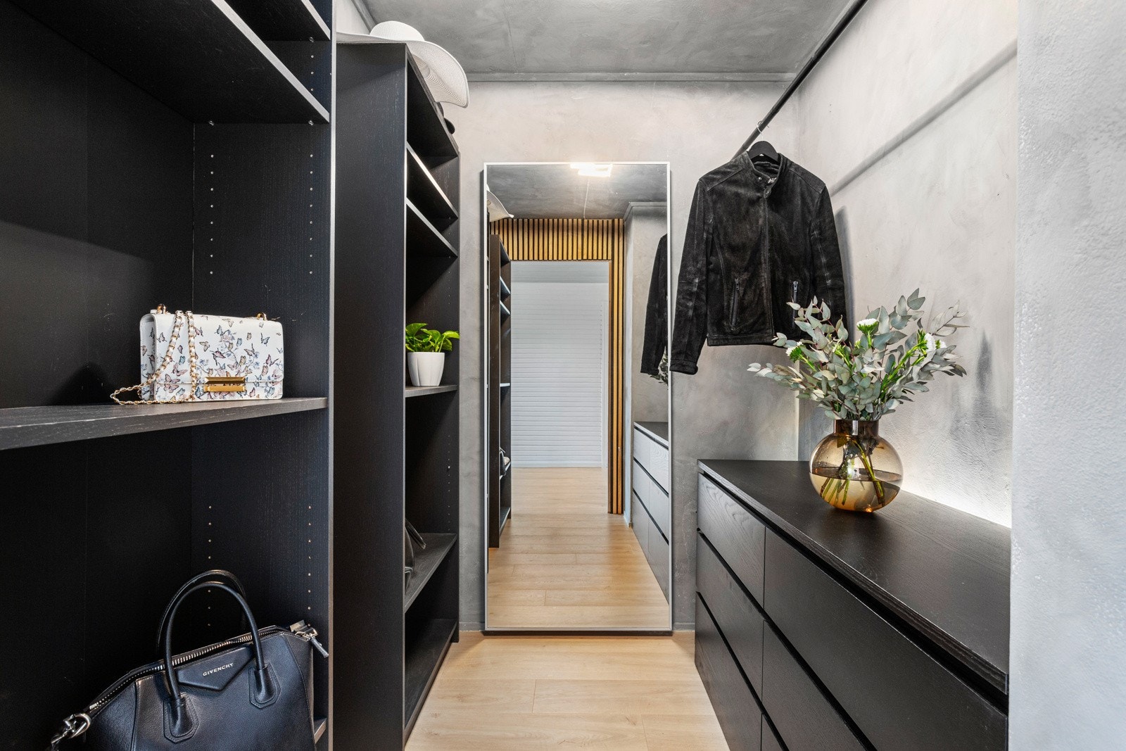 Omkledningsrommet er innredet med en åpen garderobeløsning som gir rikelig med oppbevaringsplass for klær og tilbehør Galleribilde