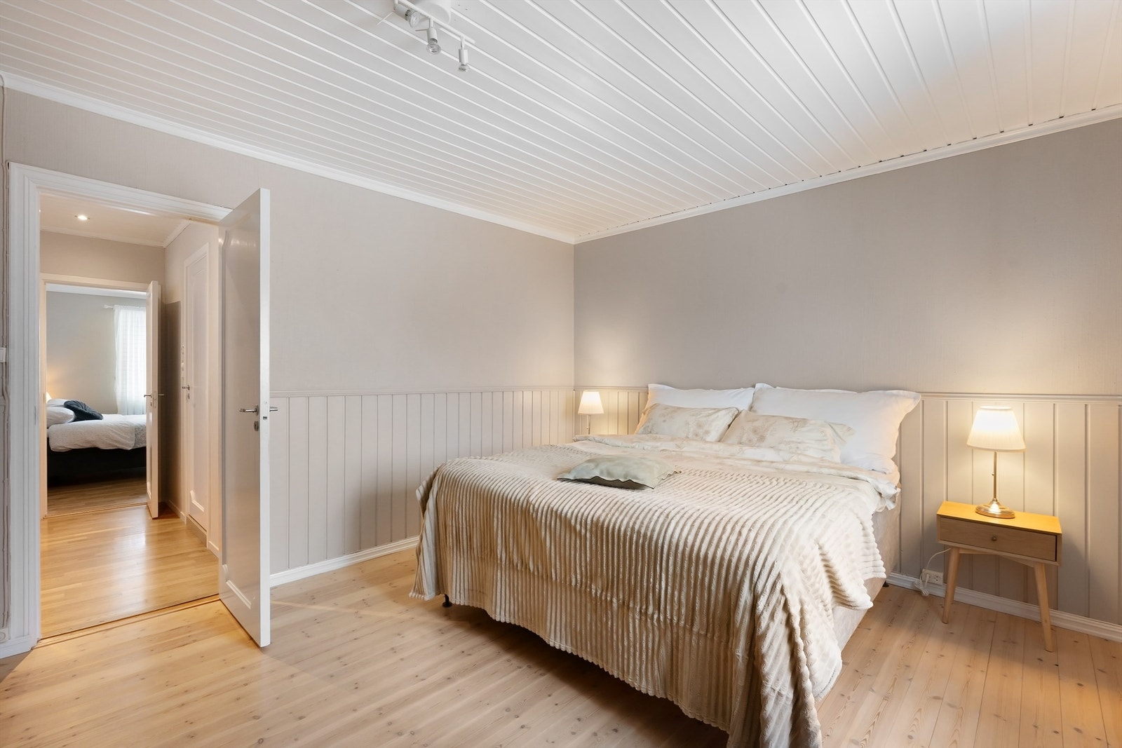 Rommet har originale gulvbord av tre og vegger med brystningspanel. Galleribilde