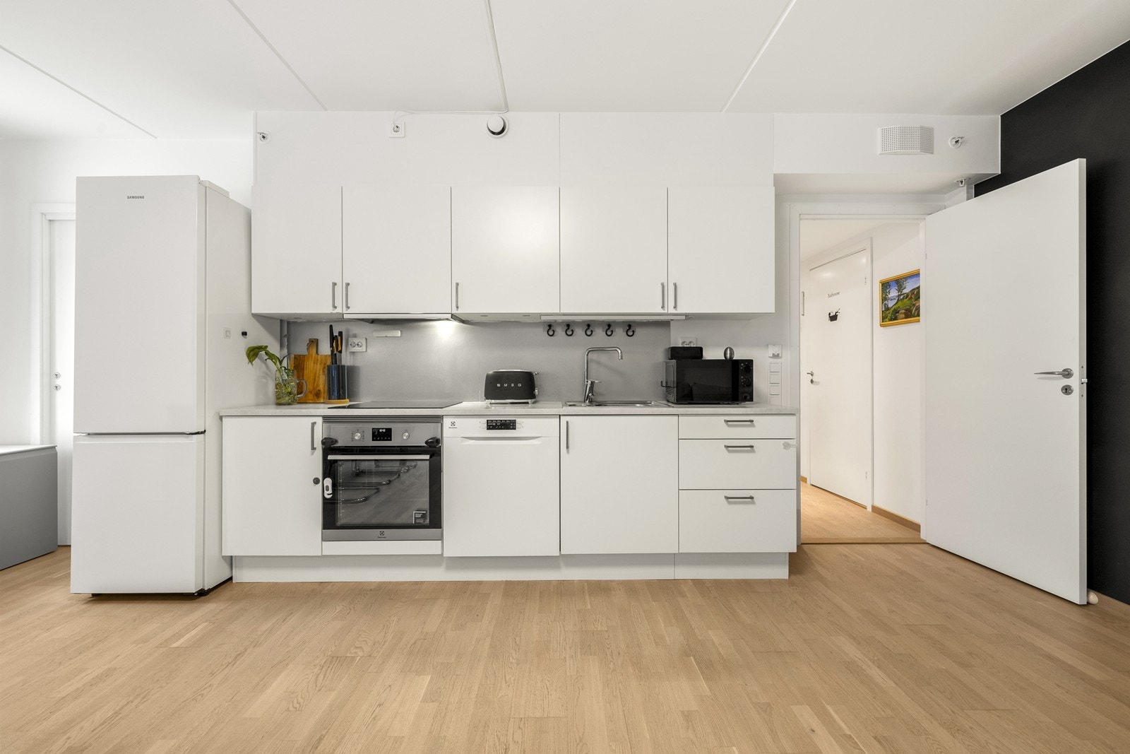 Kjøkkeninnredningen fra Sigdal har slette, lyse fronter og laminat benkeplate. Galleribilde