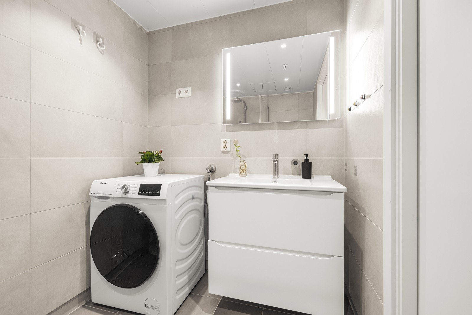 Baderomsinnredningen består av en veggmontert skuffeseksjon og speil med belysning. Galleribilde