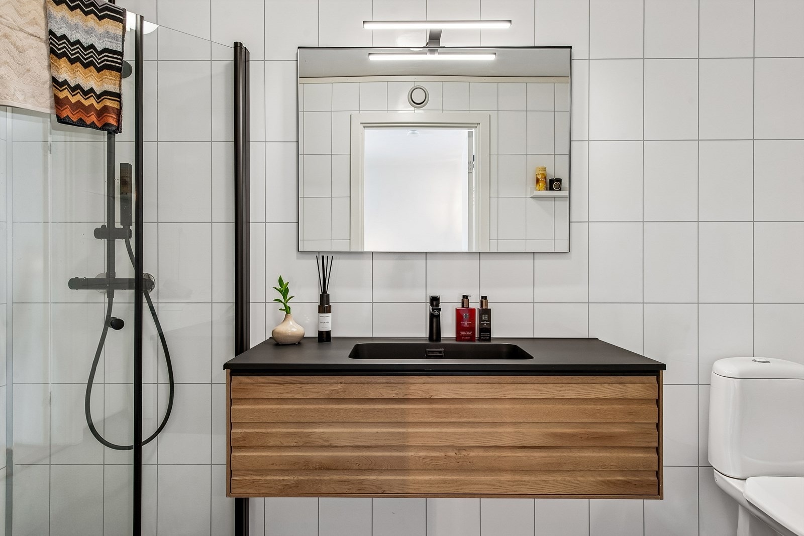 Både badet og kjøkkenet har en gjennomført stil med mørke detaljer. Galleribilde