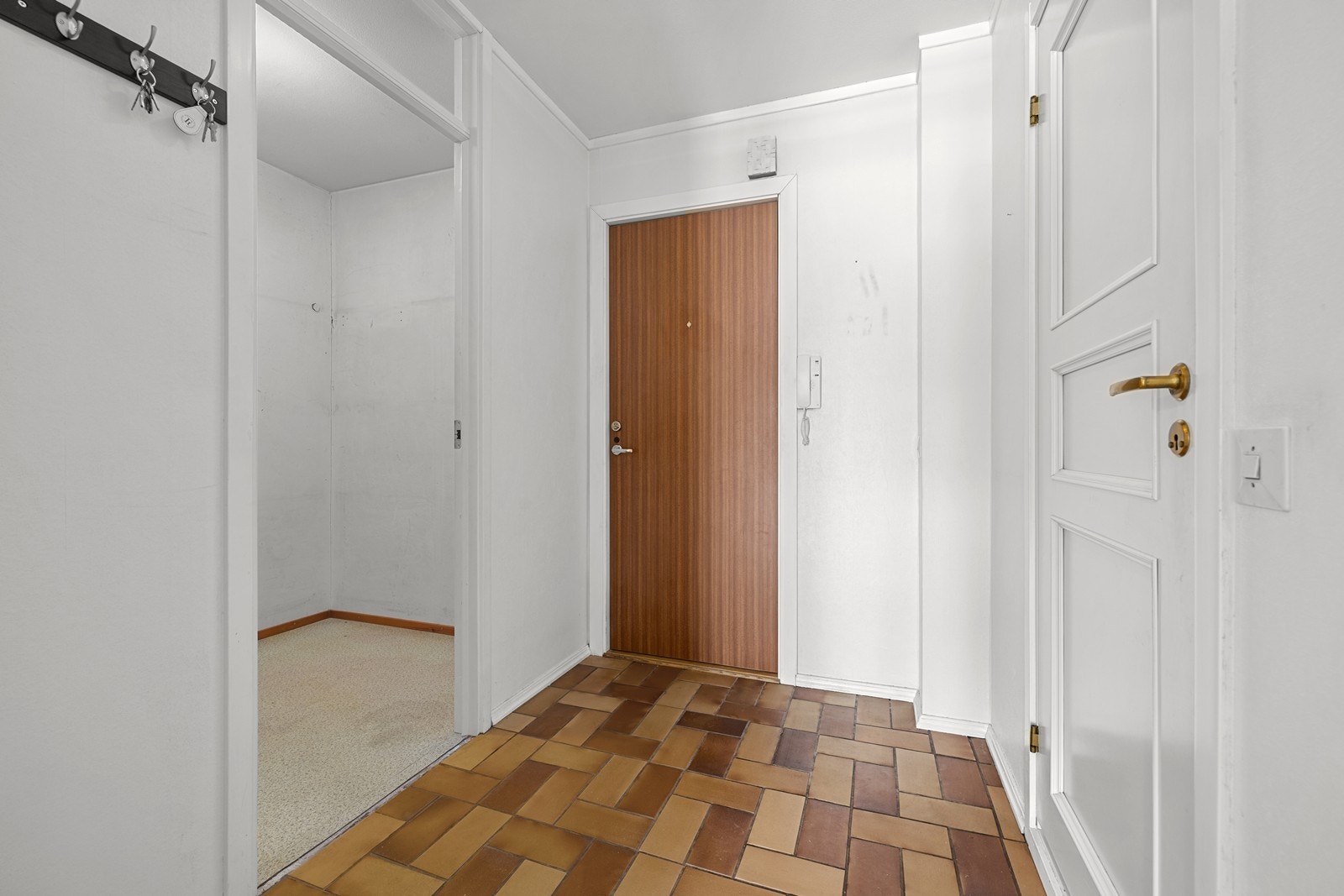 Romslig entré med flislagt gulv og plass til oppbevaring i en innvendig bod. Galleribilde