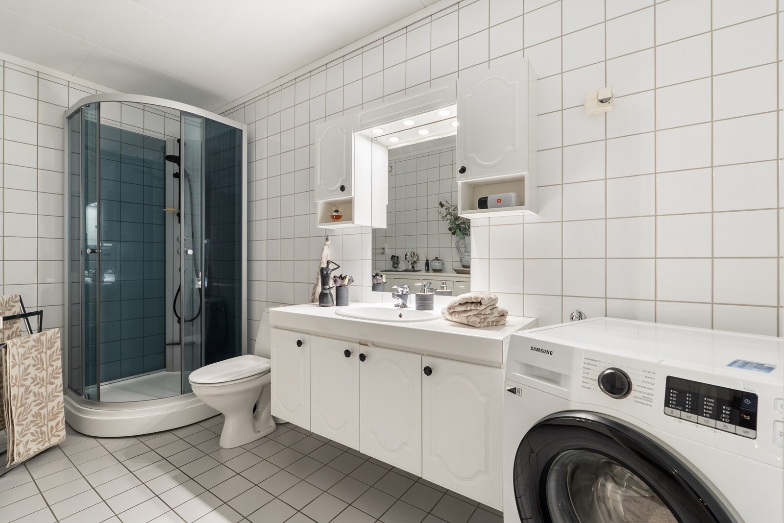 Badet er utstyrt med dusjkabinett, gulvstående toalett og opplegg for vaskemaskin. Galleribilde