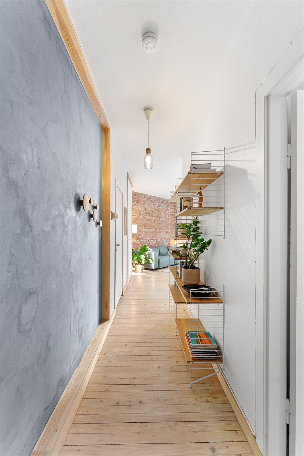 Romslig og vakker entré med kalkvegg og en perfekt plassert String-hylle Galleribilde
