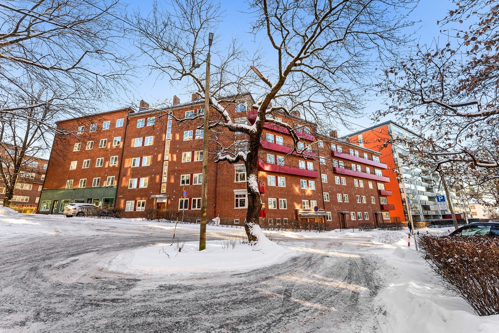 Man har parkeringskort til å parkere foran den grønne fasaden nede til venstre i bildet Galleribilde