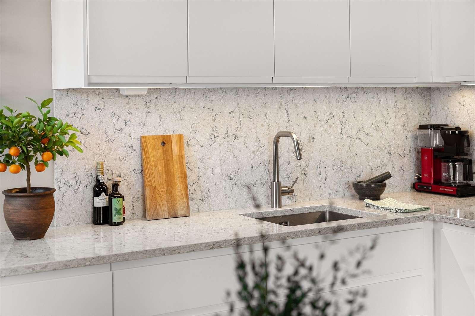 Det er benkeplate i kvarts og gode materialvalg på over- og underskap Galleribilde