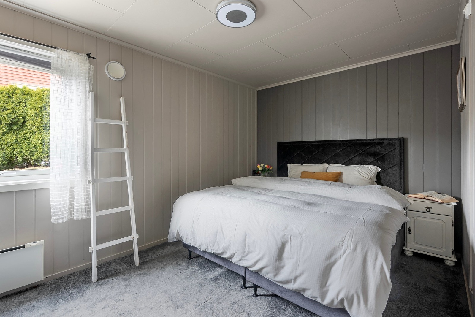 Hovedsoverom i rolige farger, med naturlig belysning fra vindu. Galleribilde