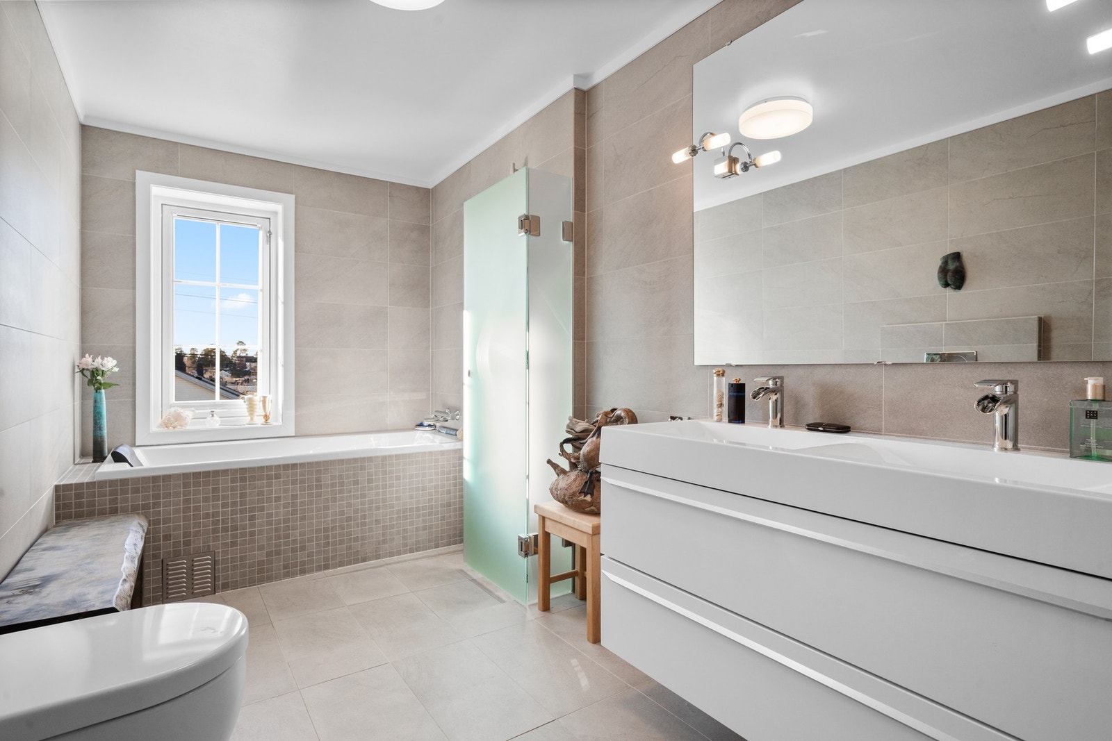 Romslig og delikat bad med varmekabler og rikelig med lagringsplass Galleribilde