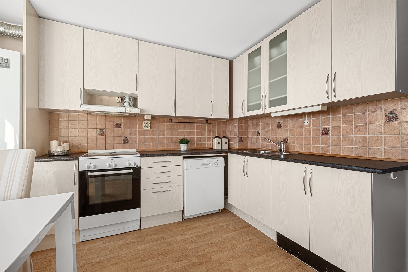 Kjøkkeninnredning med slette fronter og plass til frittstående hvitevarer Galleribilde