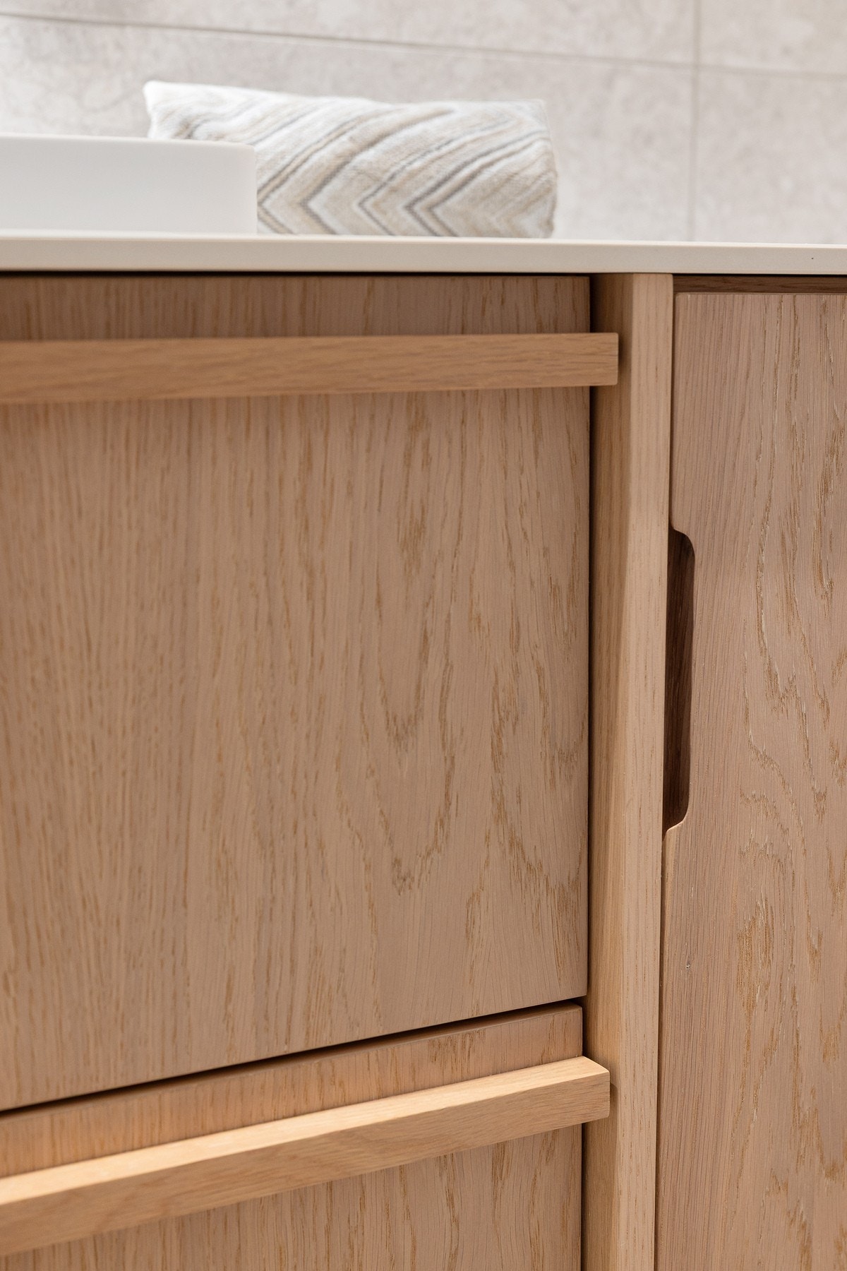 Snekkerbygget innredning med opplegg for vaskemaskin skjult i skapet til høyre Galleribilde